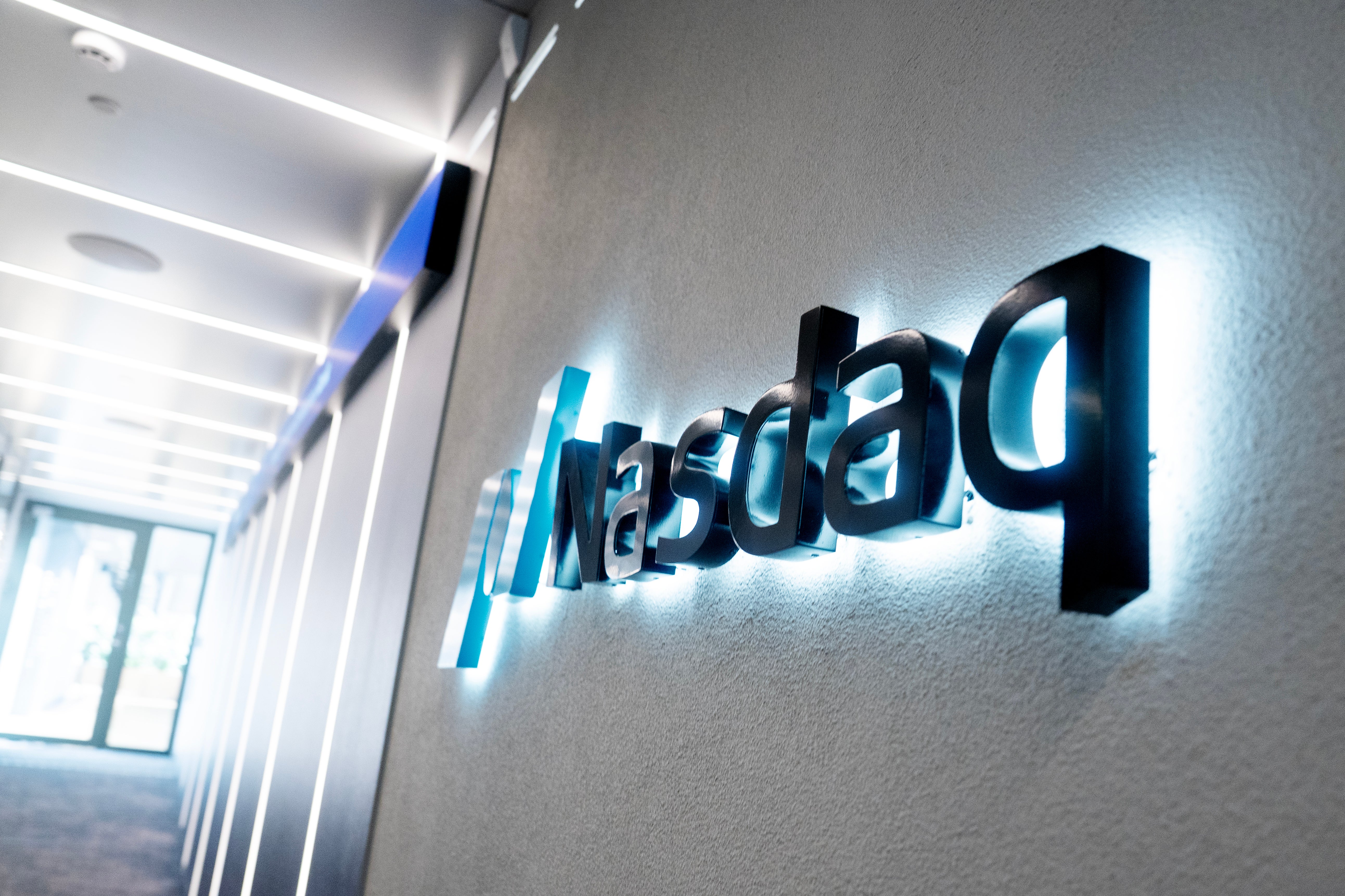Nasdaqs logotyp på en vägg i en upplyst korridor.