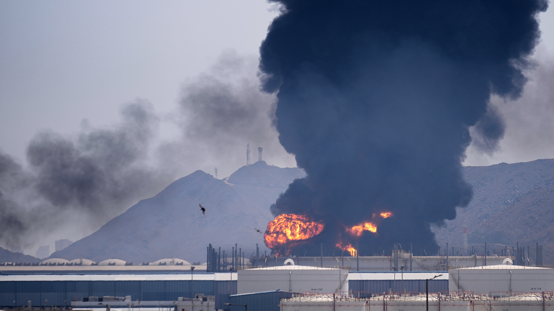 Svart rök stiger från en oljeanläggning i Förenade Arabemiraten efter att vrakdelar från en nedskjuten iransk drönare träffat området i lördags. 
