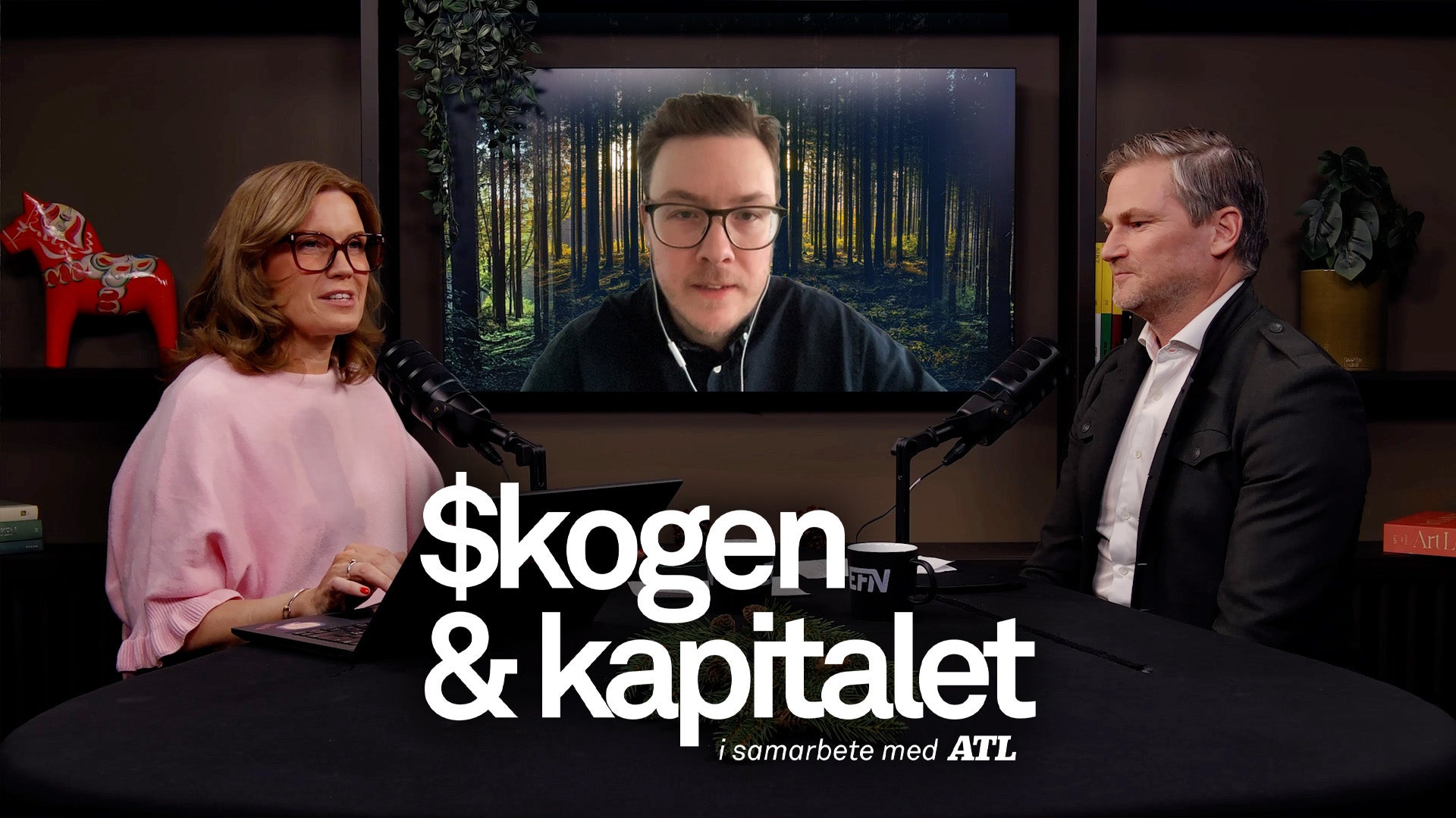 Tre personer i en podcast-inspelning diskuterar skogen och kapitalet. Två personer sitter i studion och en person är ansluten via videosamtal på en skärm bakom dem.