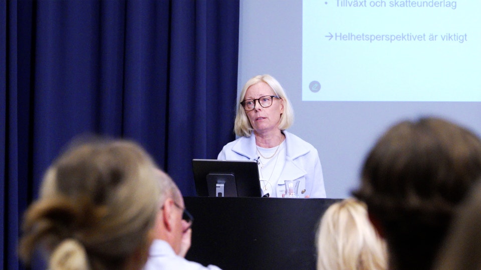 Sofia Lundberg, professor i nationalekonomi vid Handelshögskolan vid Umeå universitet står på scen, i förgrunden syns publiken.