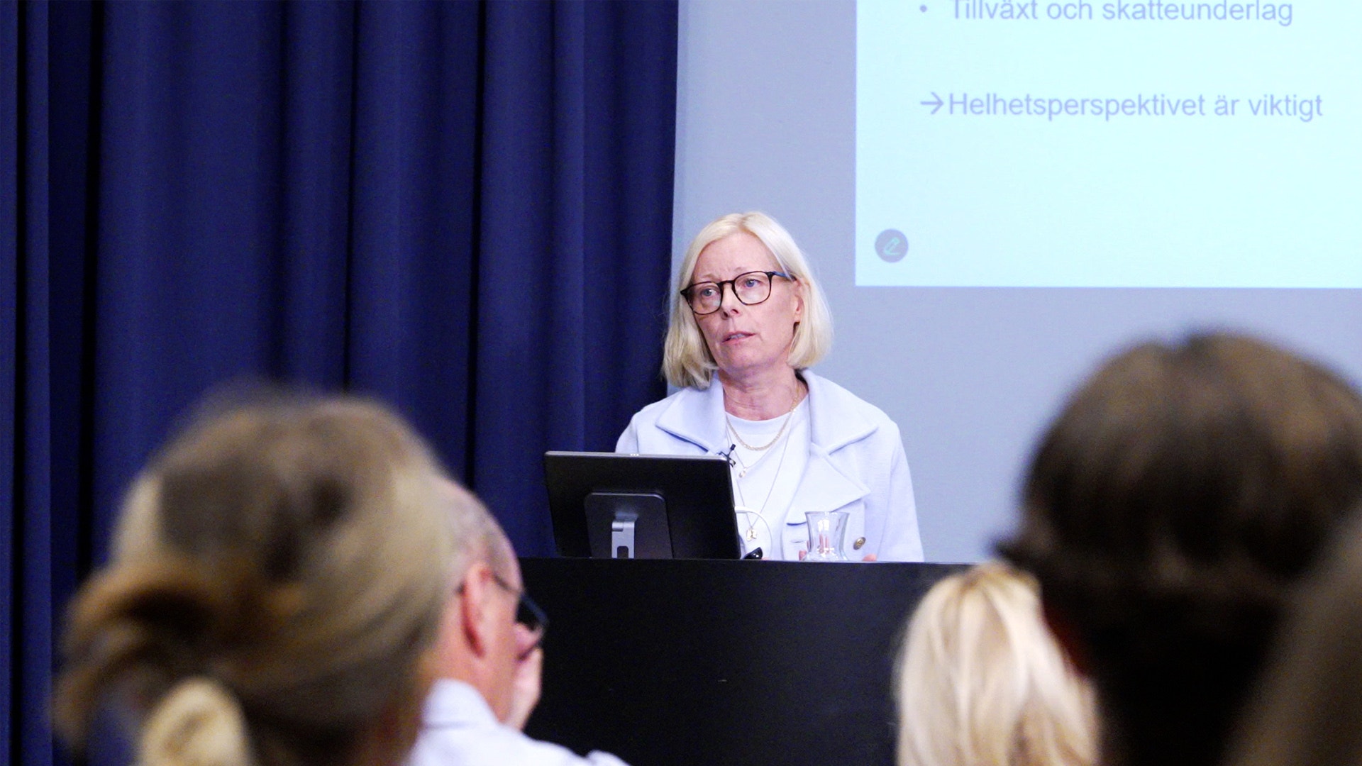 Sofia Lundberg, professor i nationalekonomi vid Handelshögskolan vid Umeå universitet står på scen, i förgrunden syns publiken.