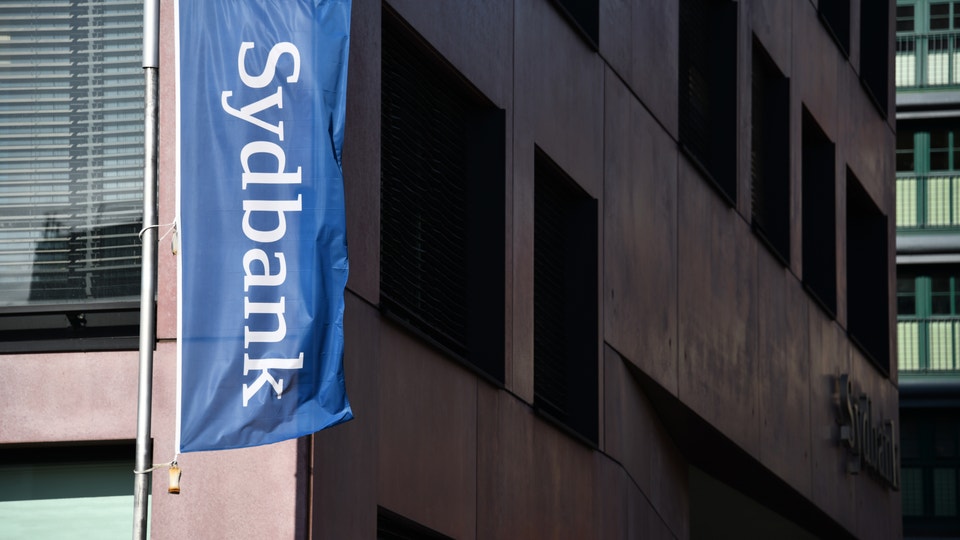 Sydbanks flagga utanför kontorsbyggnad.