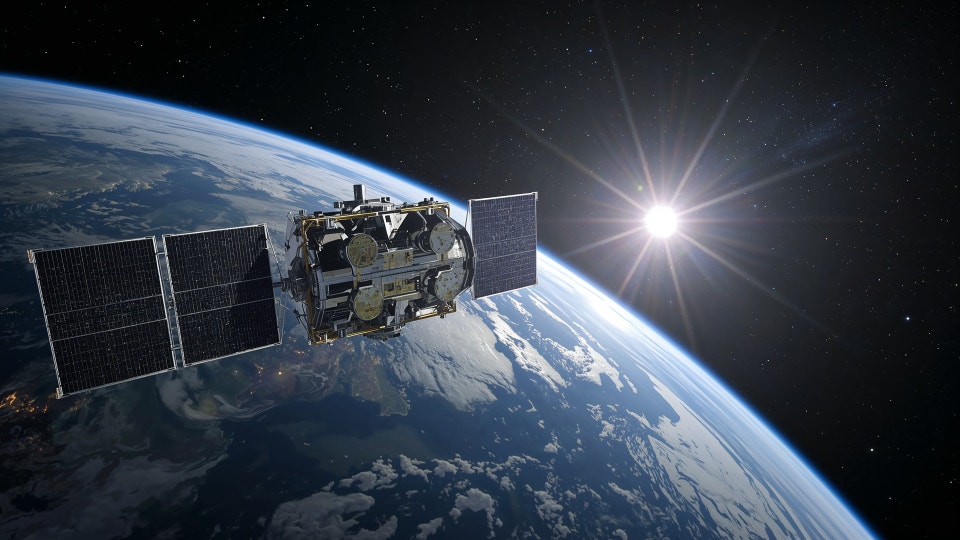 Satellit med solpaneler i omloppsbana runt jorden med solen lysande i bakgrunden.