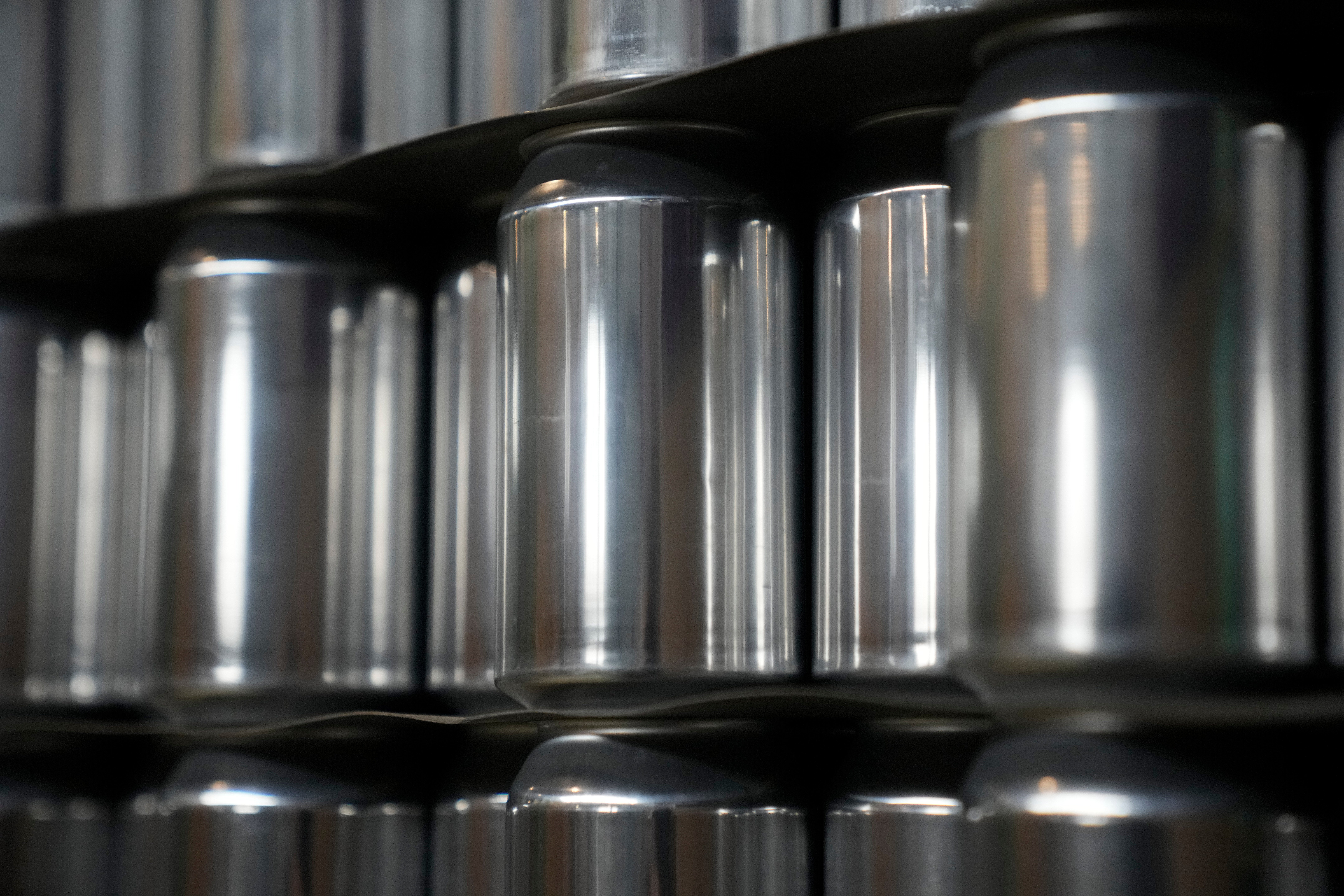 Rad av metalliska cylindriska behållare på hyllor