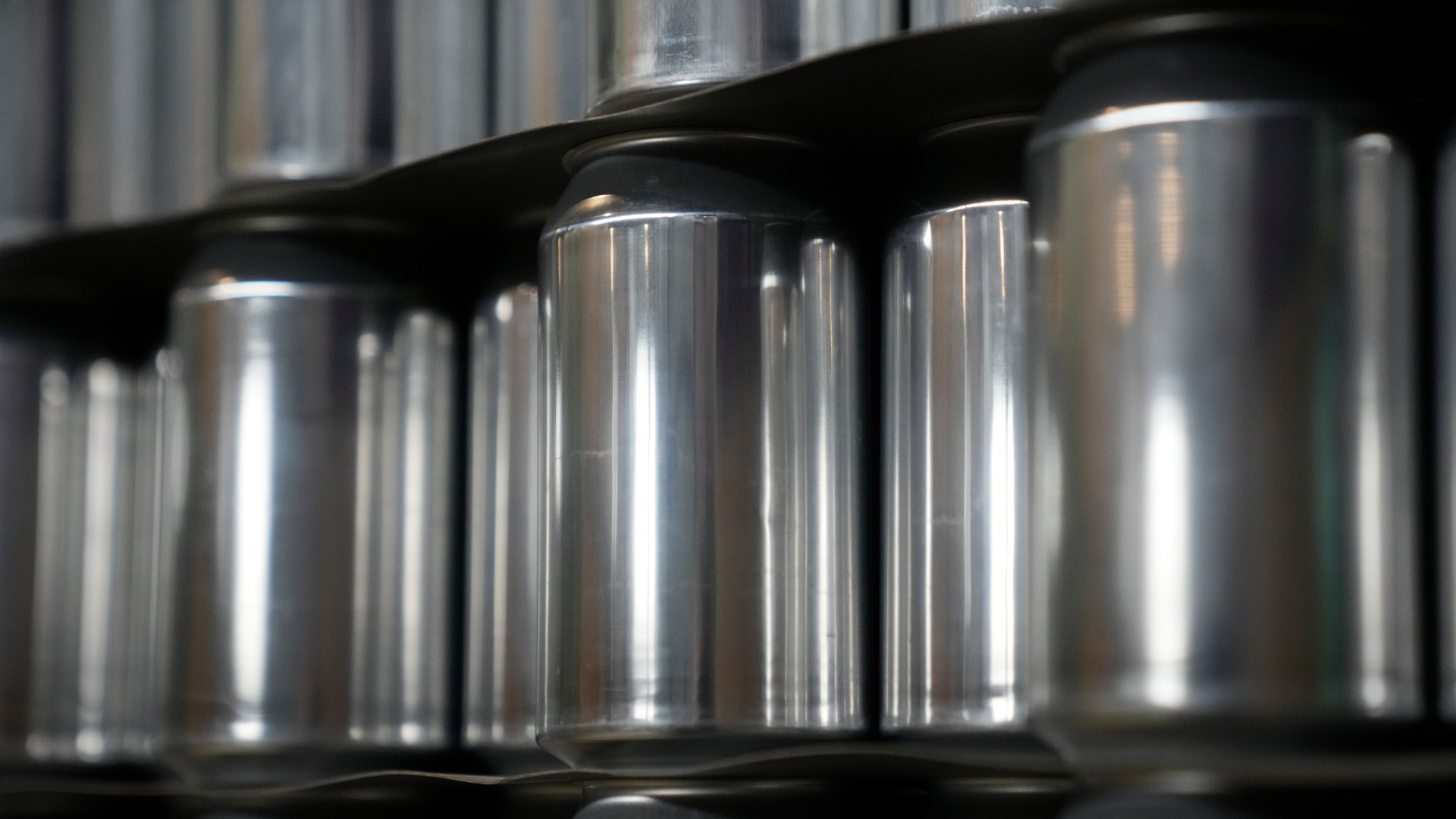 Rad av metalliska cylindriska behållare på hyllor