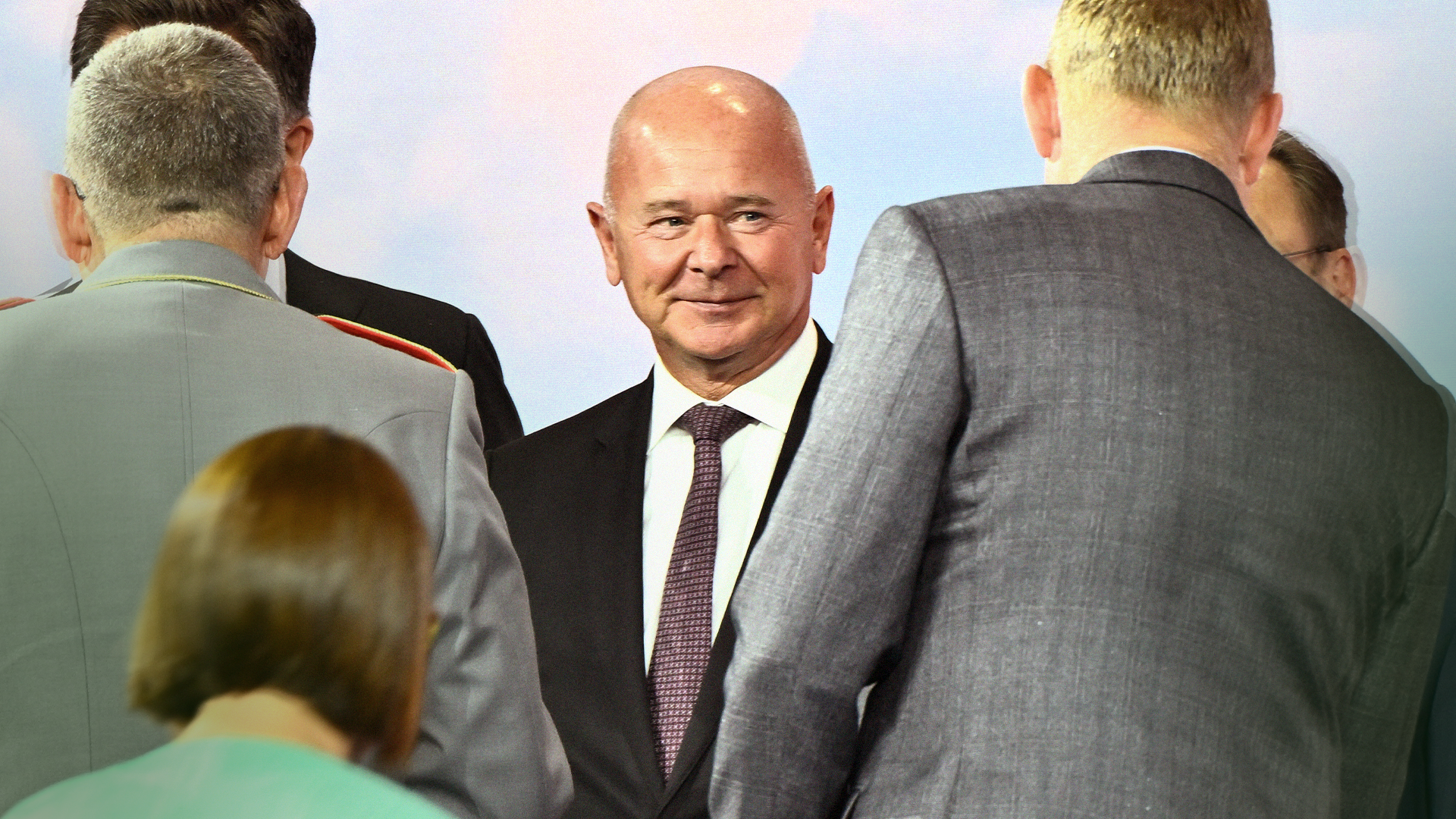 En grupp affärsmän i kostym och slips står tillsammans och samtalar.