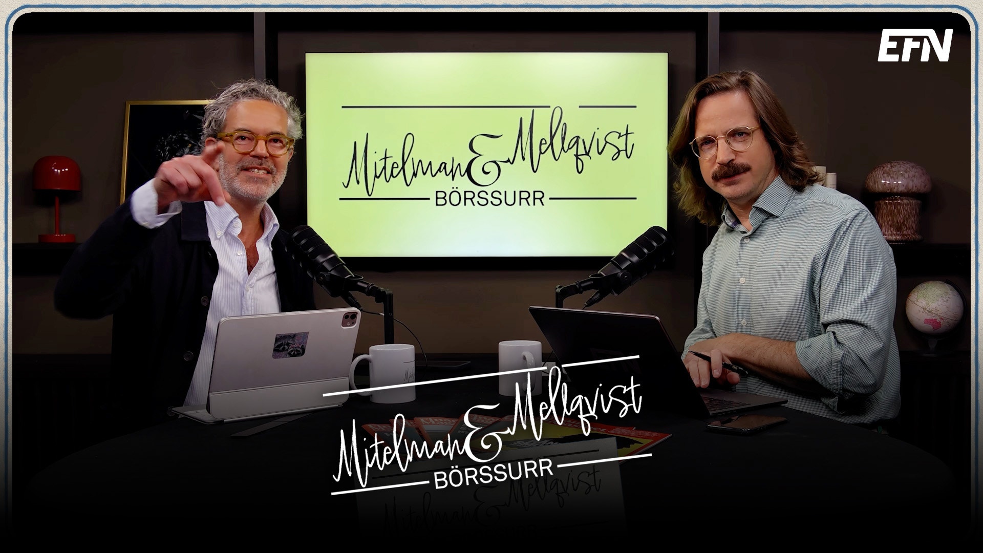 Två män sitter vid ett bord i en studiomiljö under inspelning av podcasten Michaels Aldgvist Börssurr. De är omgivna av skärmar som visar programmets logotyp.