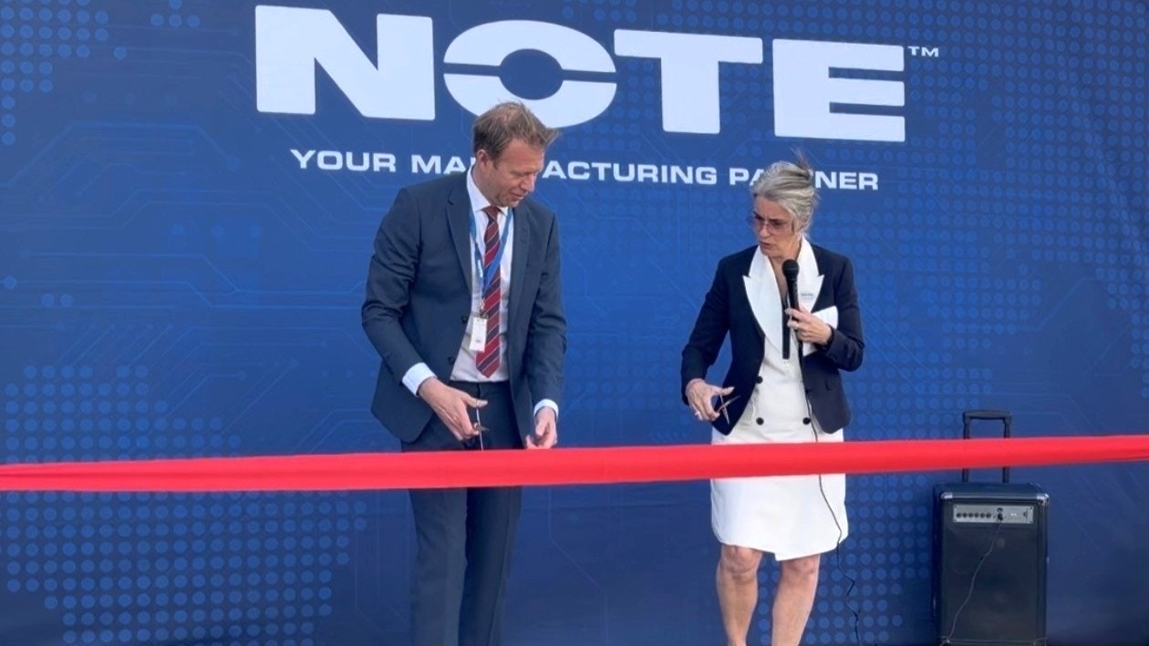 Två personer i affärskläder inviger en event vid ett rött band framför en blå bakgrund med NOTE-logotypen.