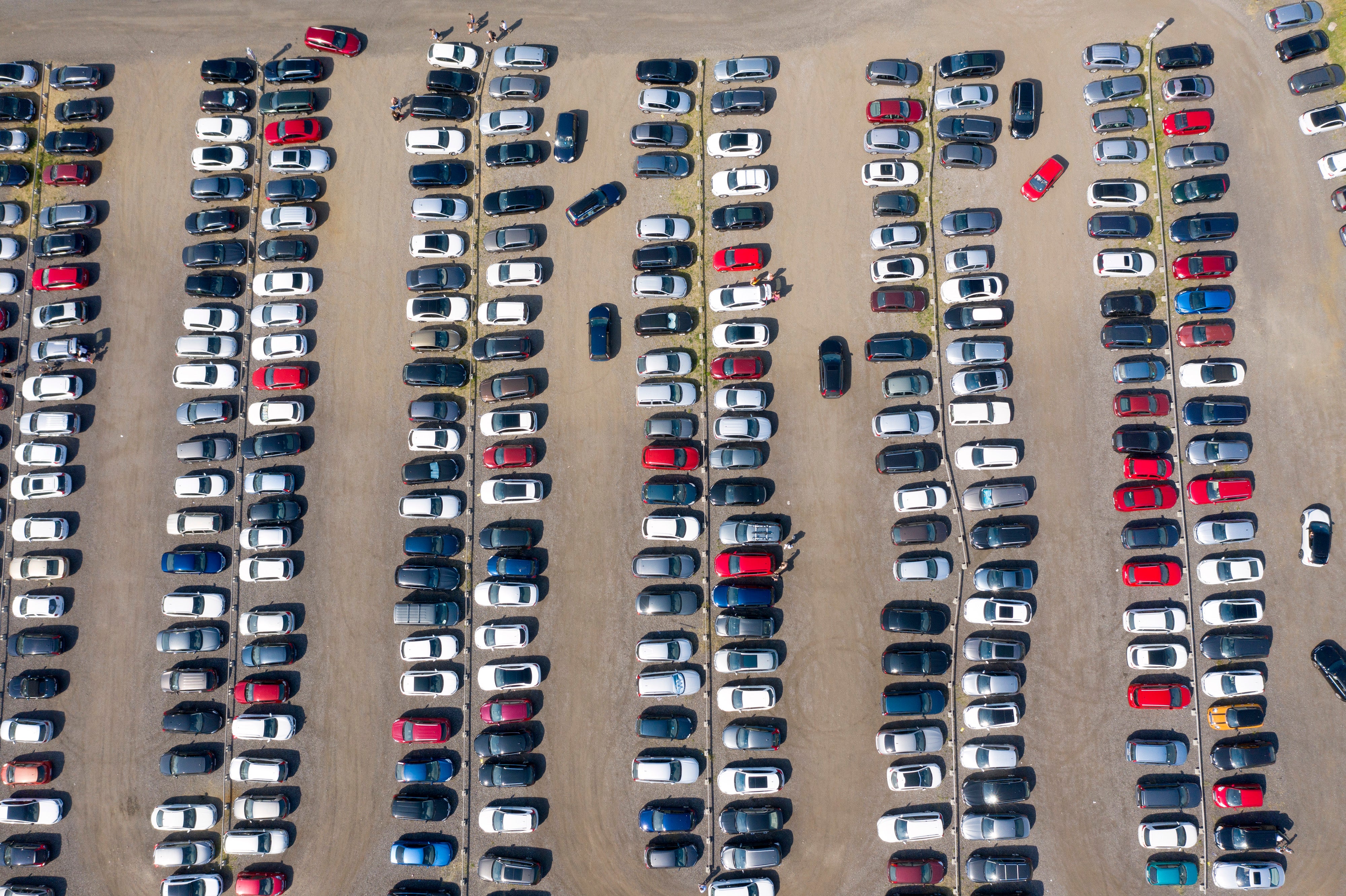 Flygfoto över en stor parkeringsplats med många bilar ordnade i rader