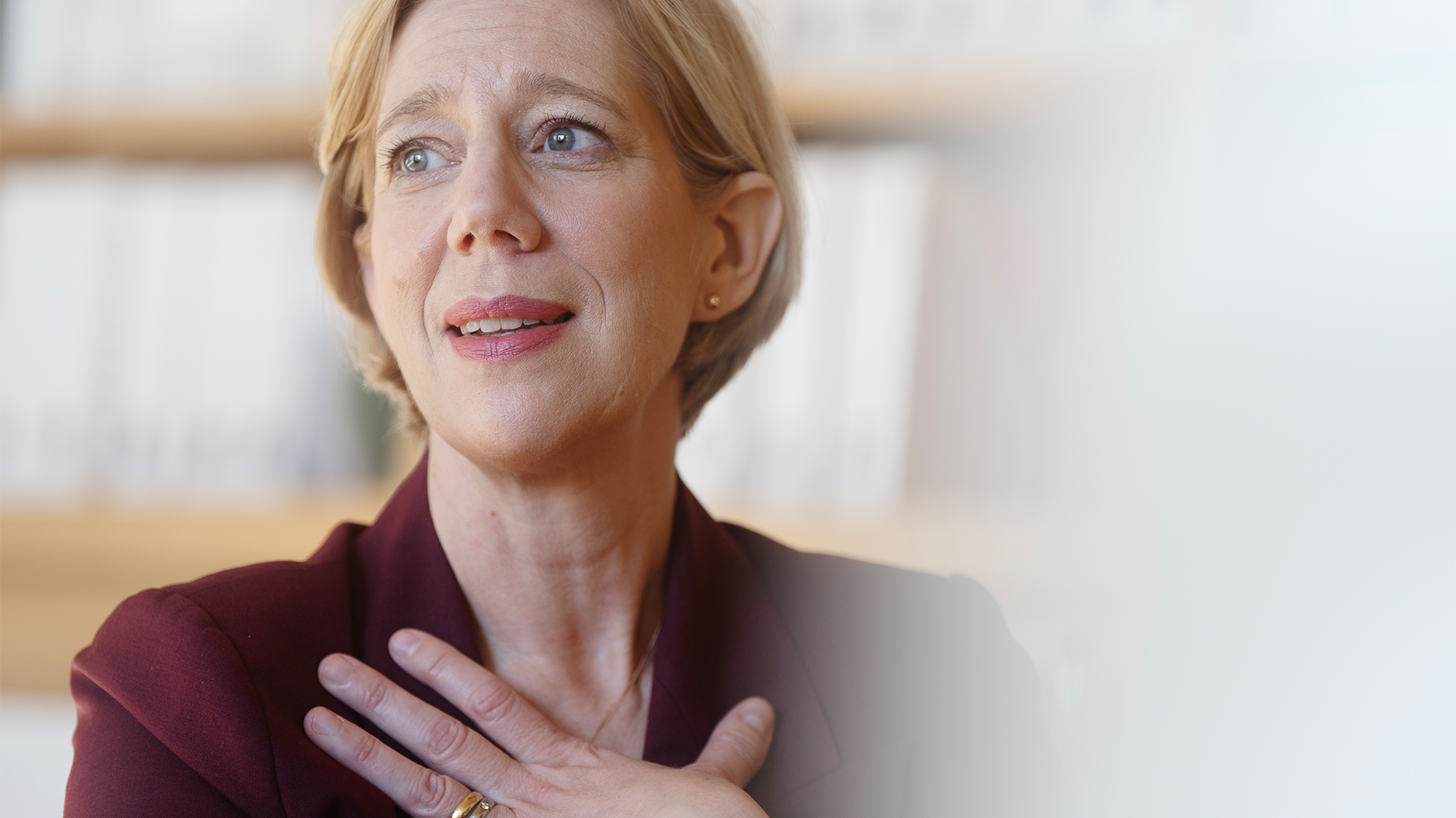 Anna Breman sitter vid ett bort i Riksbankens lokaler. Hon har handen på hjärtat.