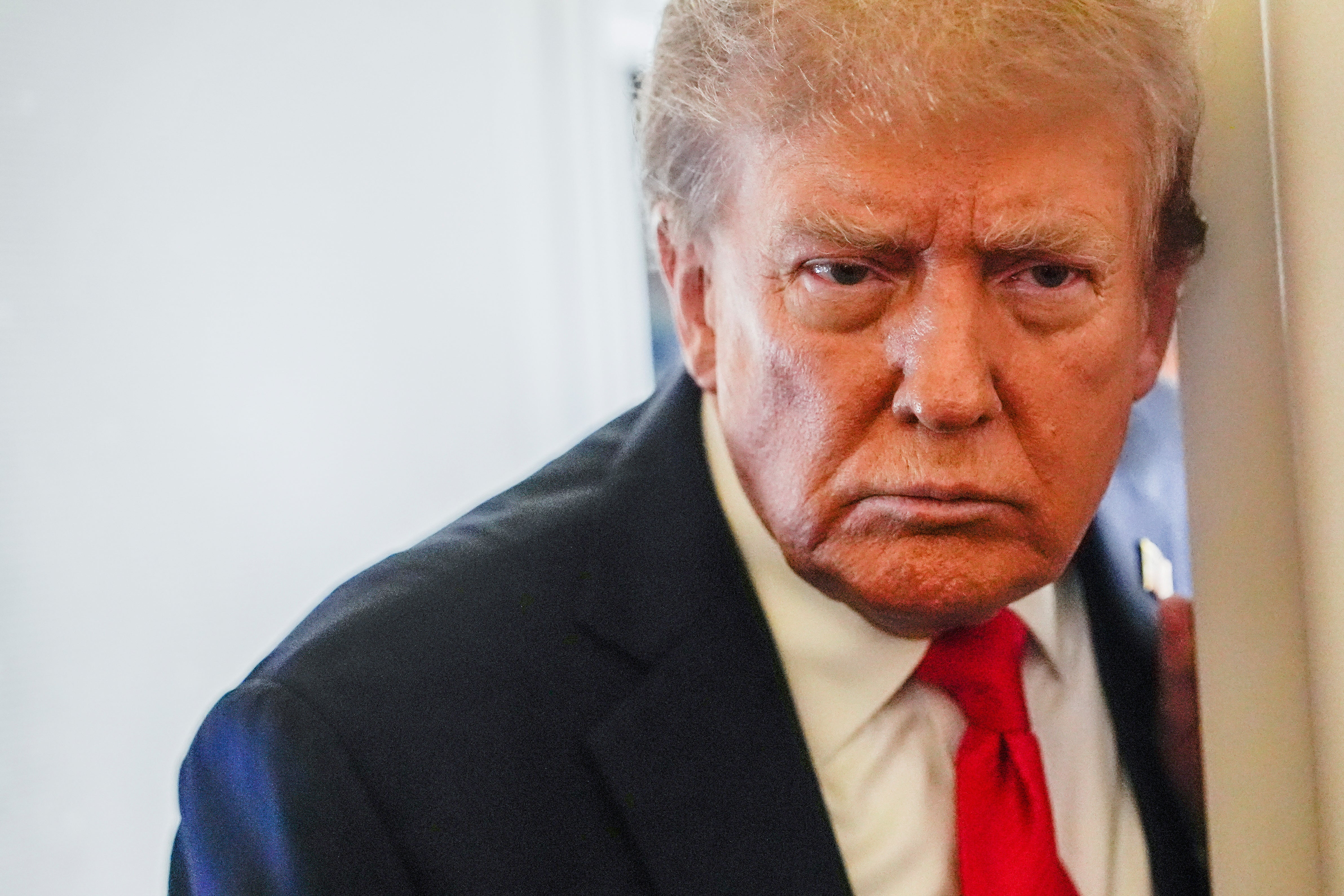 Trump ser bestämd ut när han möter reportrarna i Alaska.