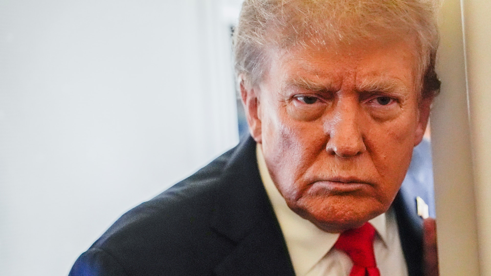 Trump ser bestämd ut när han möter reportrarna i Alaska.