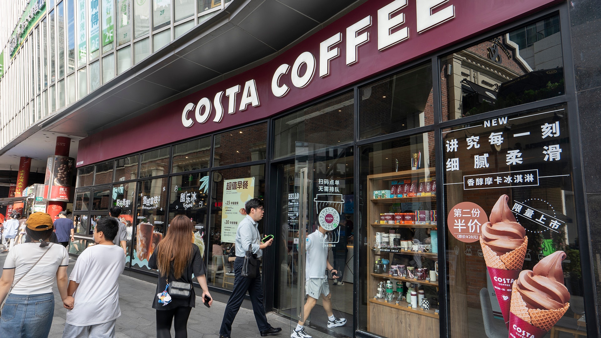Entrén till ett Costa Coffee-kafé med människor som går förbi på gatan utanför.