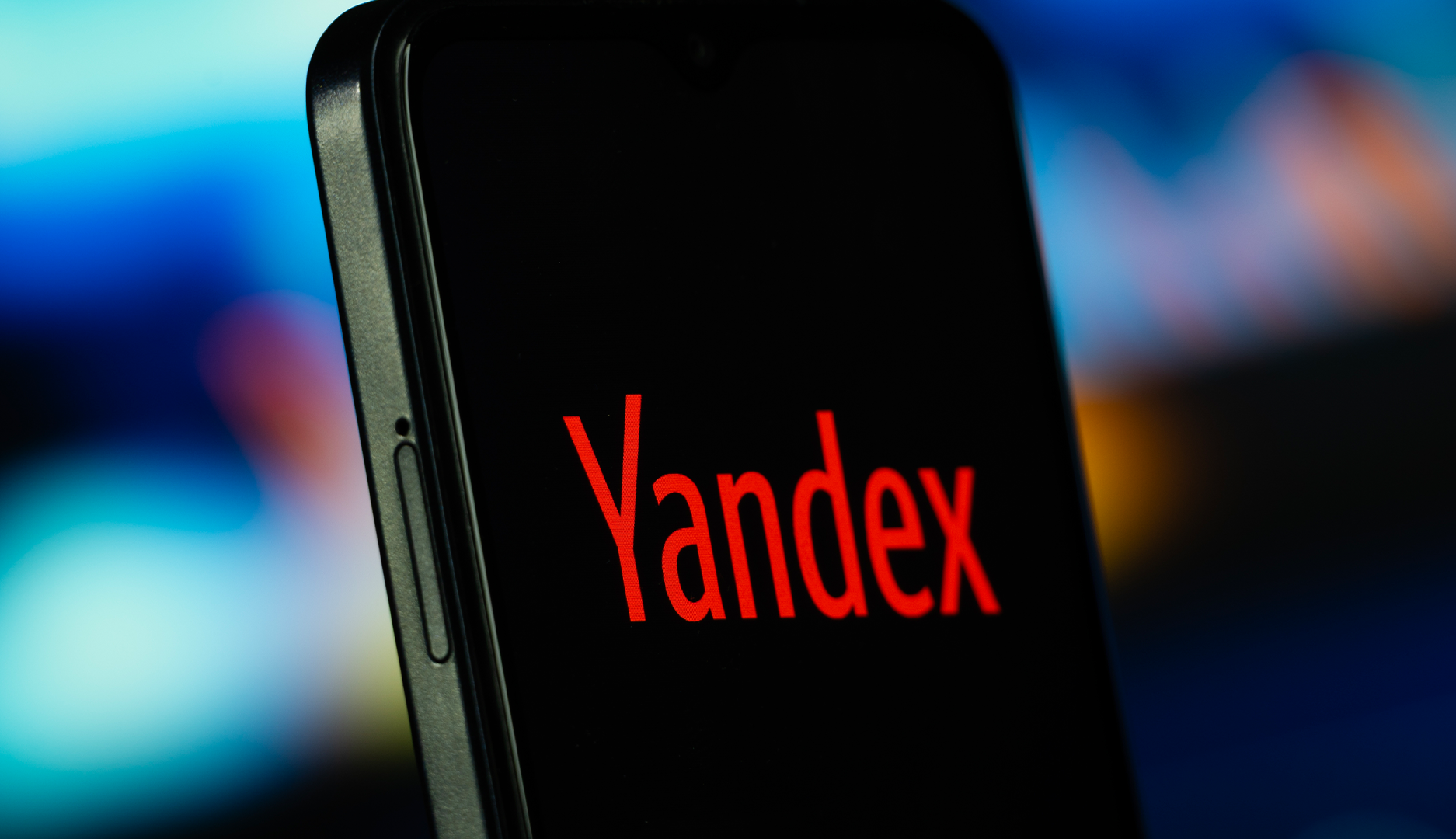 En mobiltelefon med svart skärm där det står Yandex i röd text.