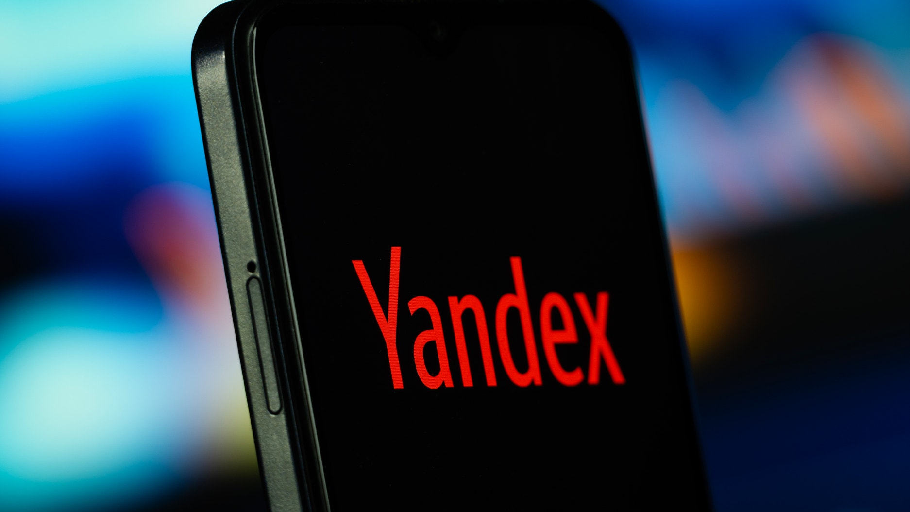 En mobiltelefon med svart skärm där det står Yandex i röd text.