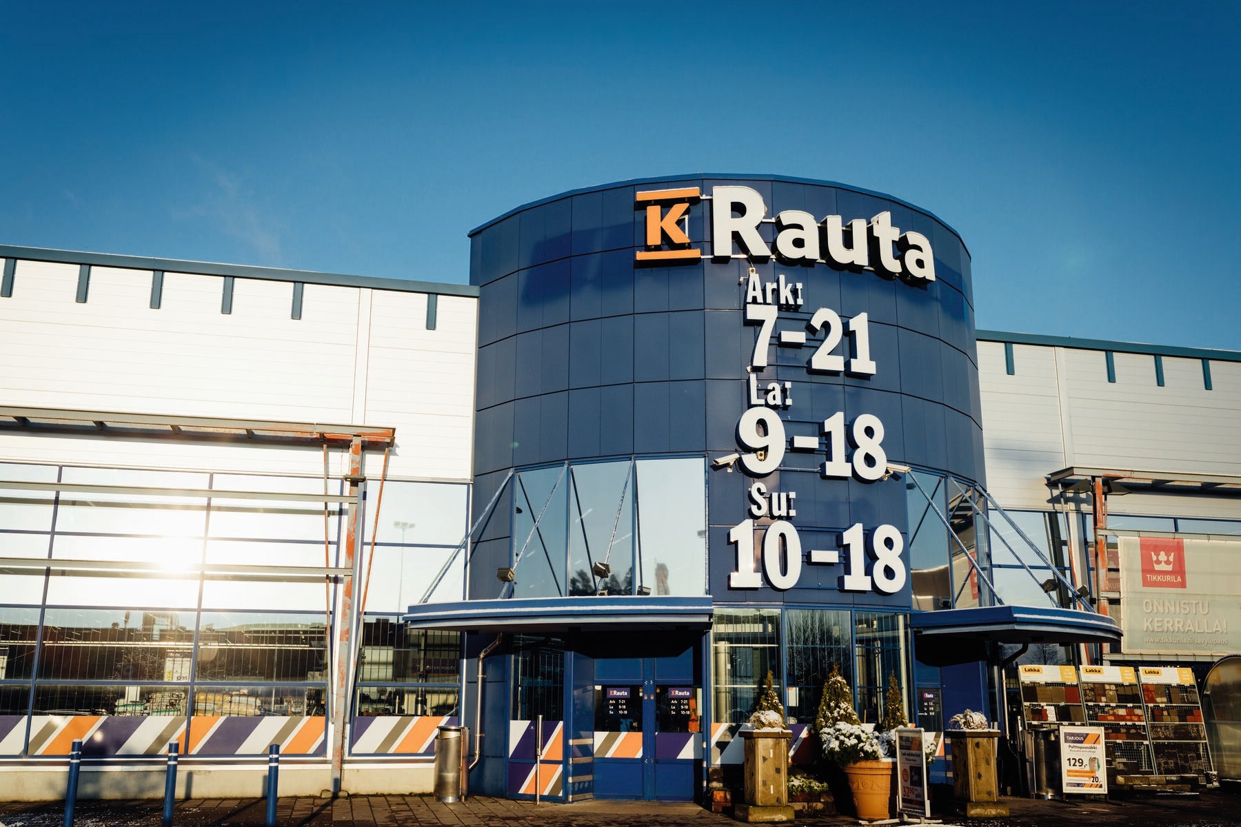 K-Rauta byggvarubutik med cylindriskt blått torn och öppettider på fasaden