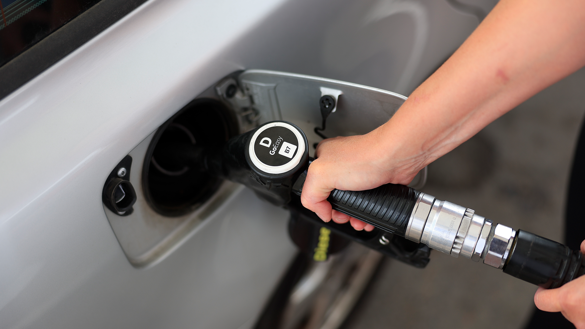 En person tankar diesel i en bil vid en bensinstation.