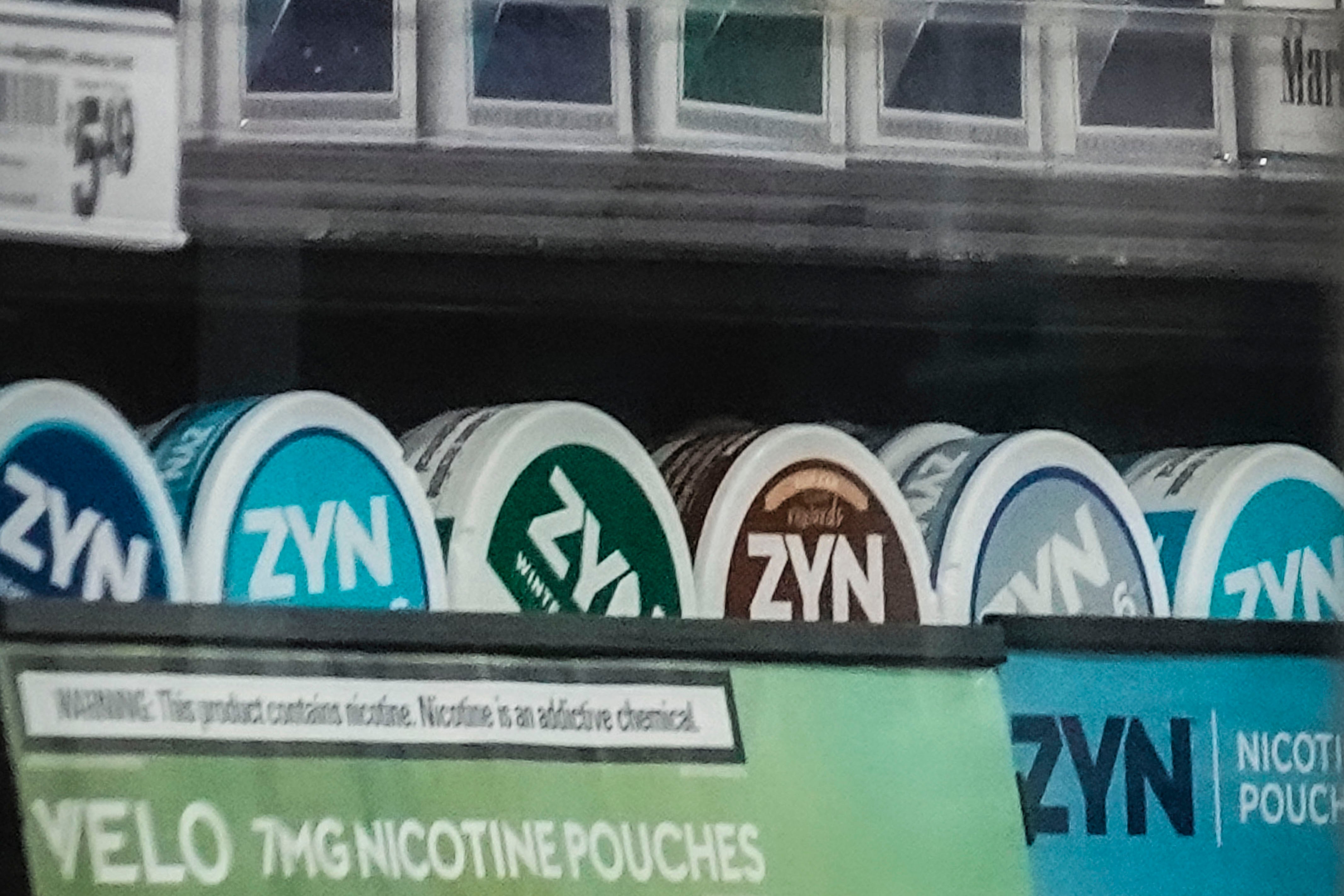 Rad med nikotinpåsar av märket ZYN i olika smaker på en butikshylla.