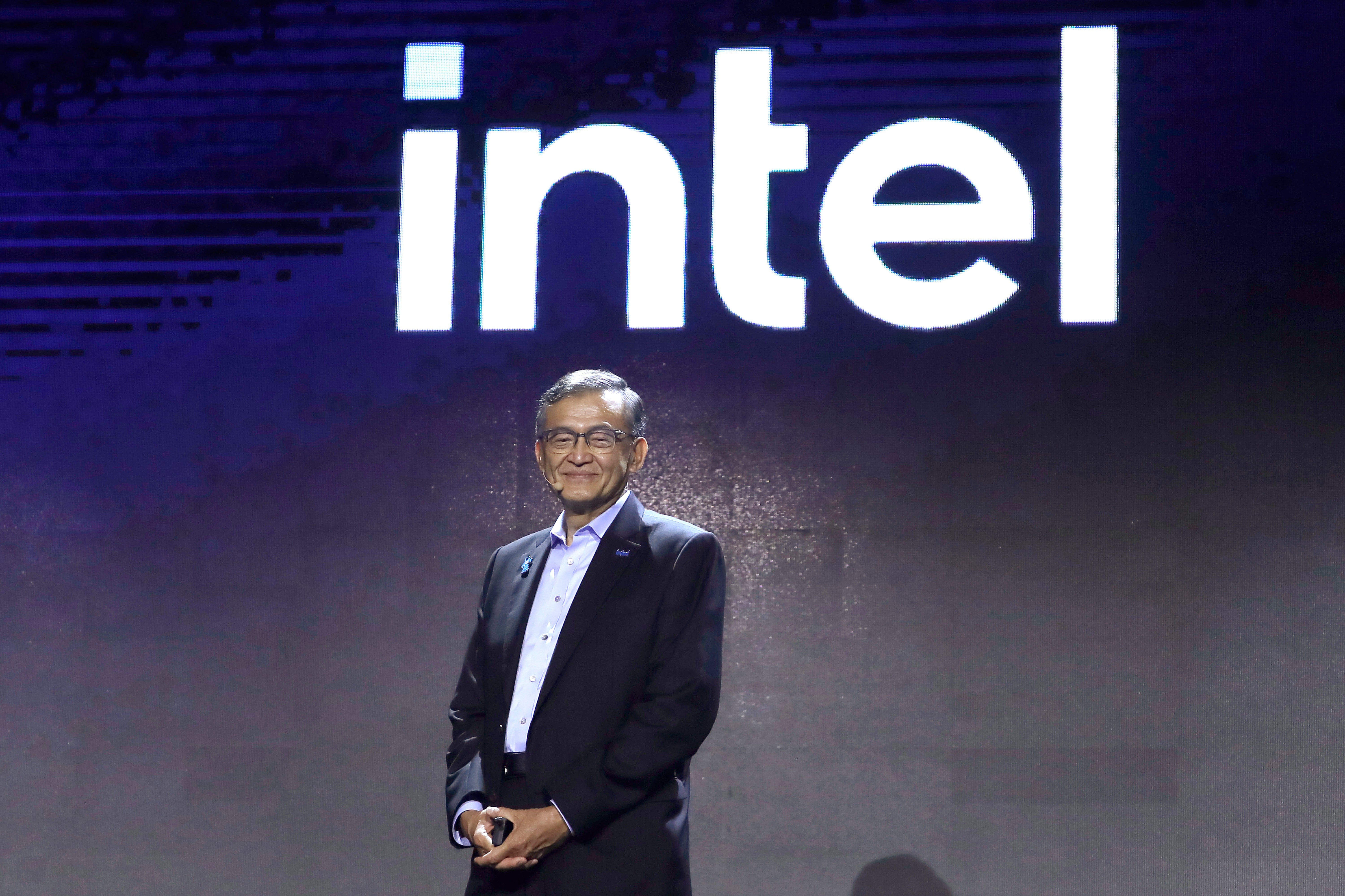 Man i kostym presenterar på scen framför Intel-logotyp