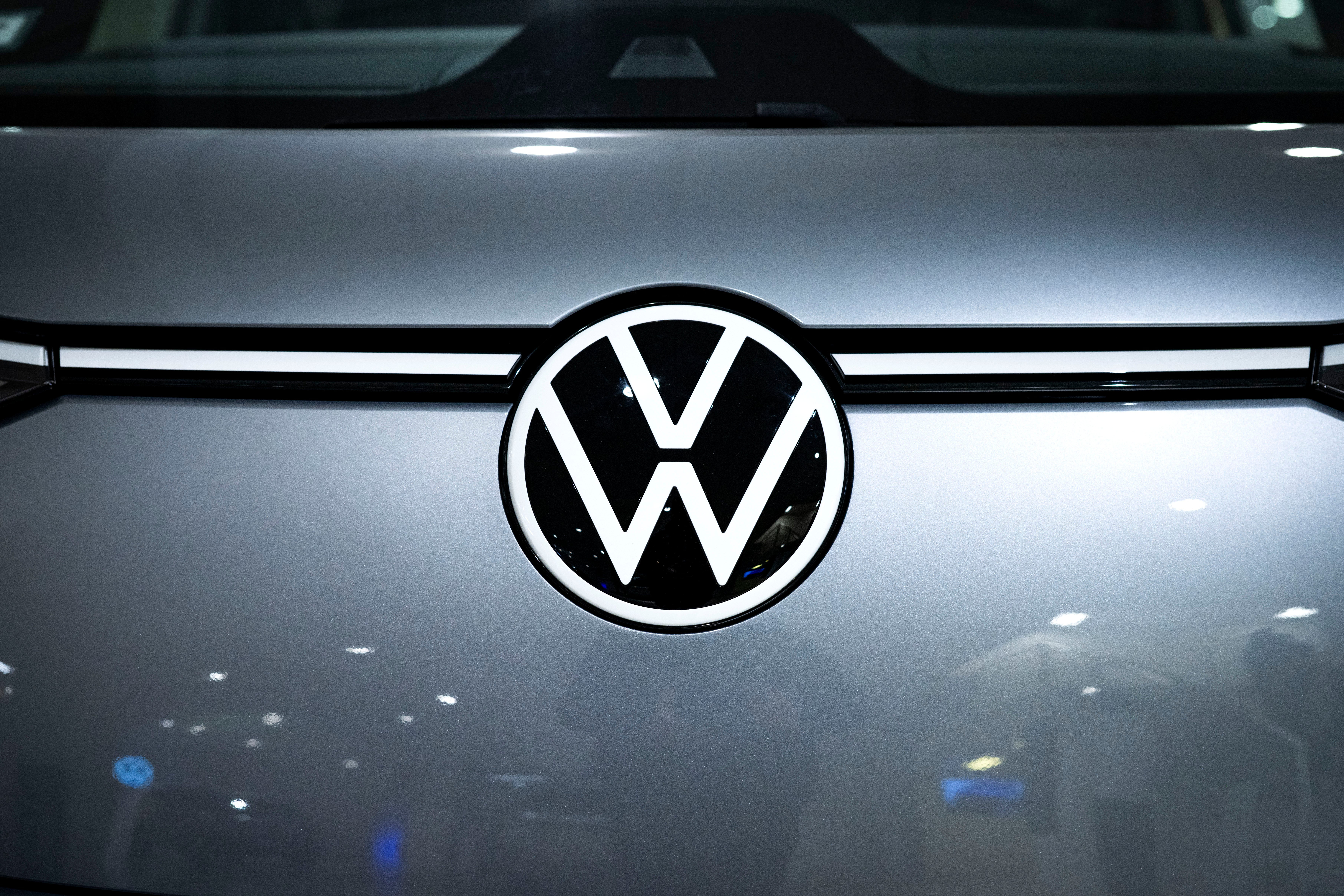 Volkswagens logotyp på en bil. En vit cirkel med VW-bokstäver på en mörkgrå bilfront.