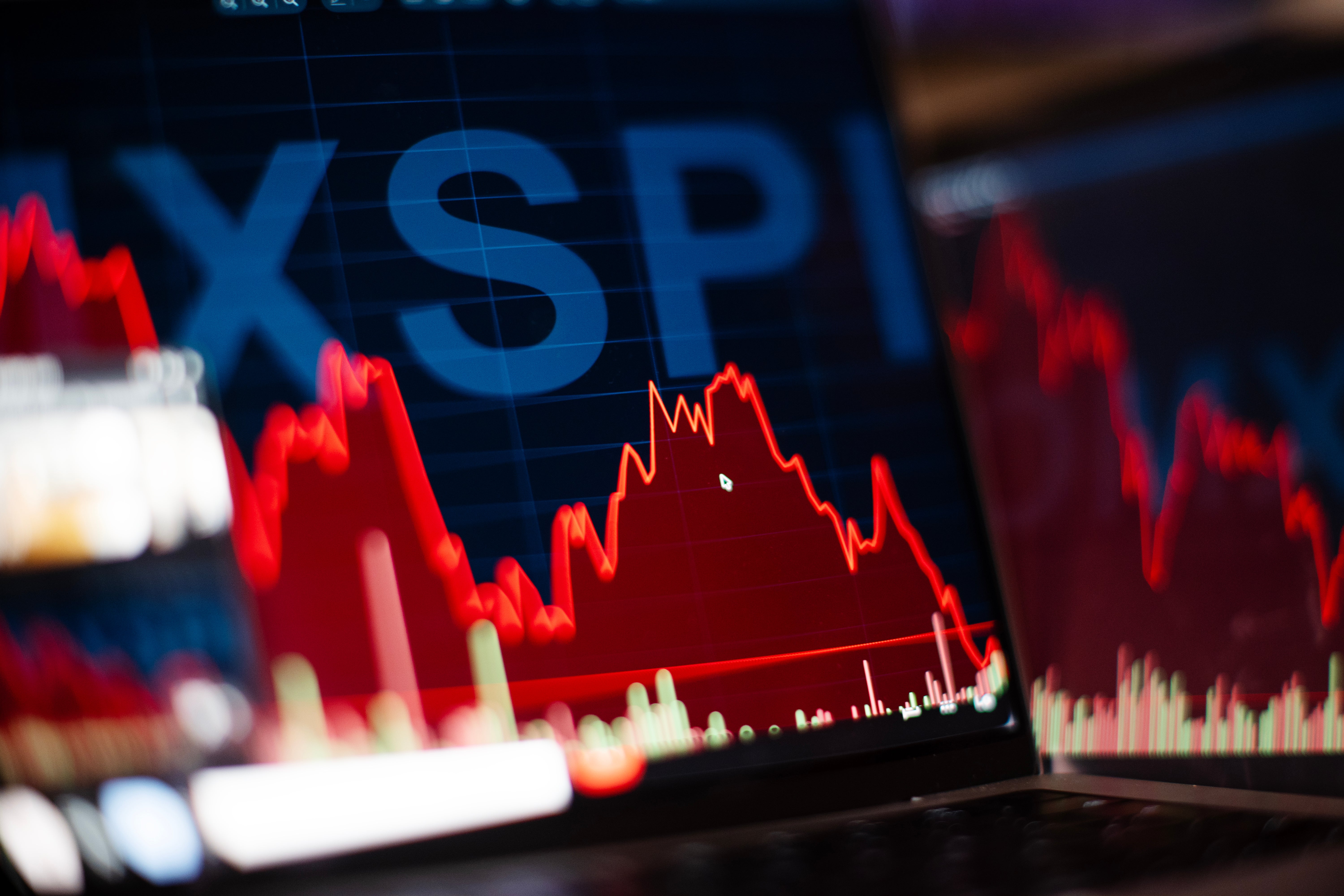 Finansiell graf som visar aktiekursutveckling med röda och vita linjer på en blå skärm med S&P-index synligt.