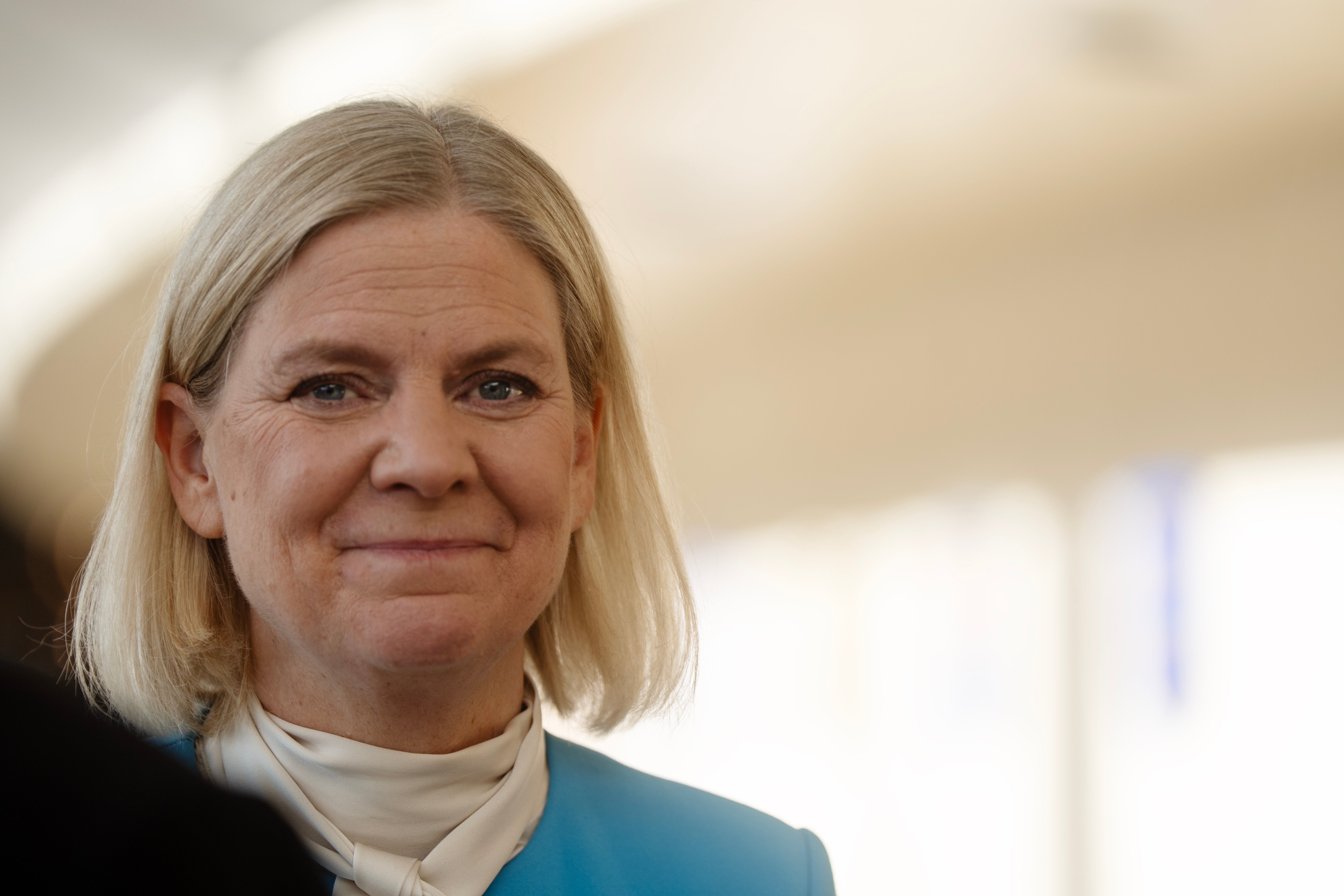 Magdalena Andersson leende, klädd i blå kavaj, inomhus.