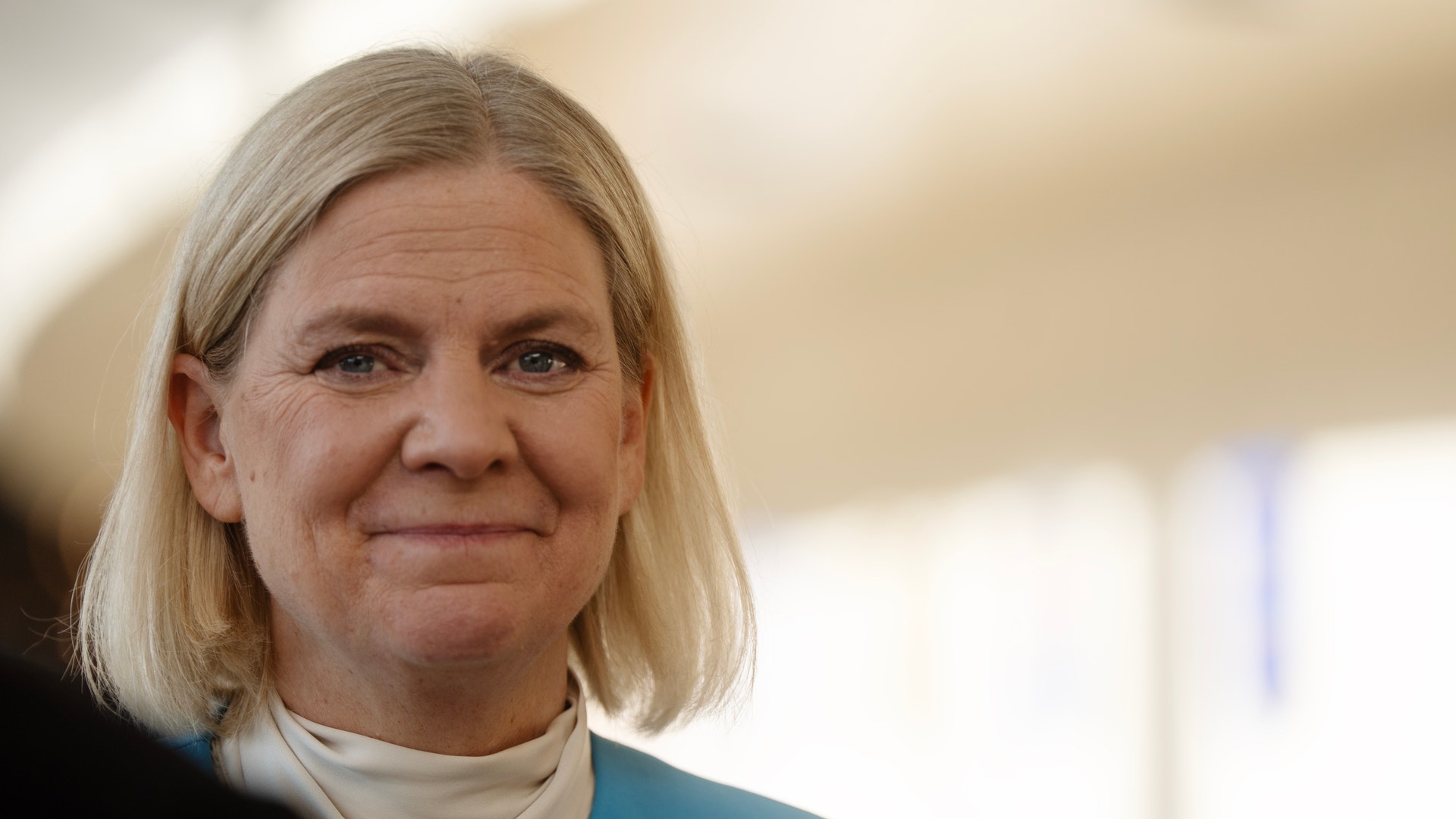 Magdalena Andersson leende, klädd i blå kavaj, inomhus.