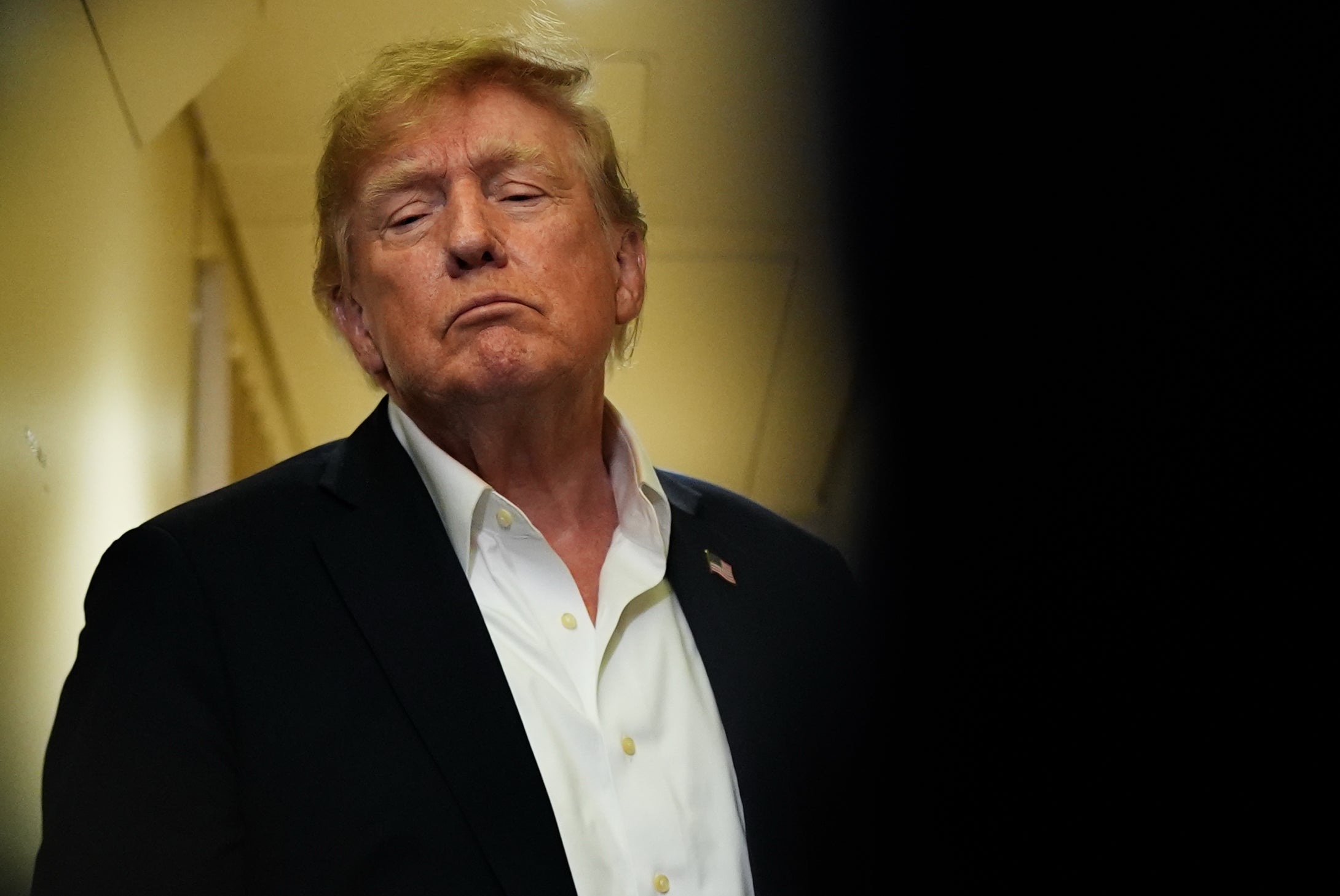 USA:s president Donald Trump med vit skjorta och kavaj, fotograferad inomhus.