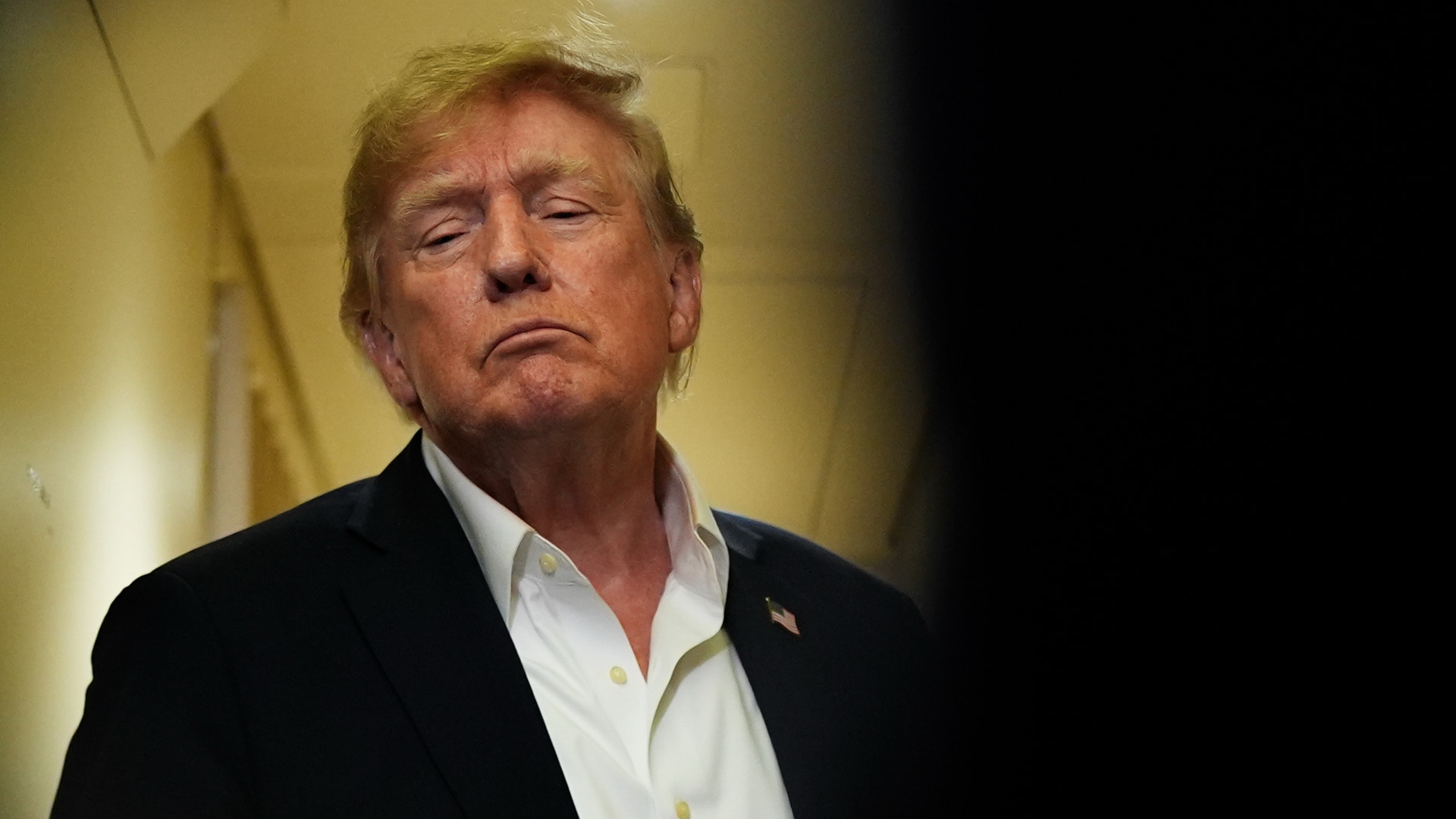 USA:s president Donald Trump med vit skjorta och kavaj, fotograferad inomhus.
