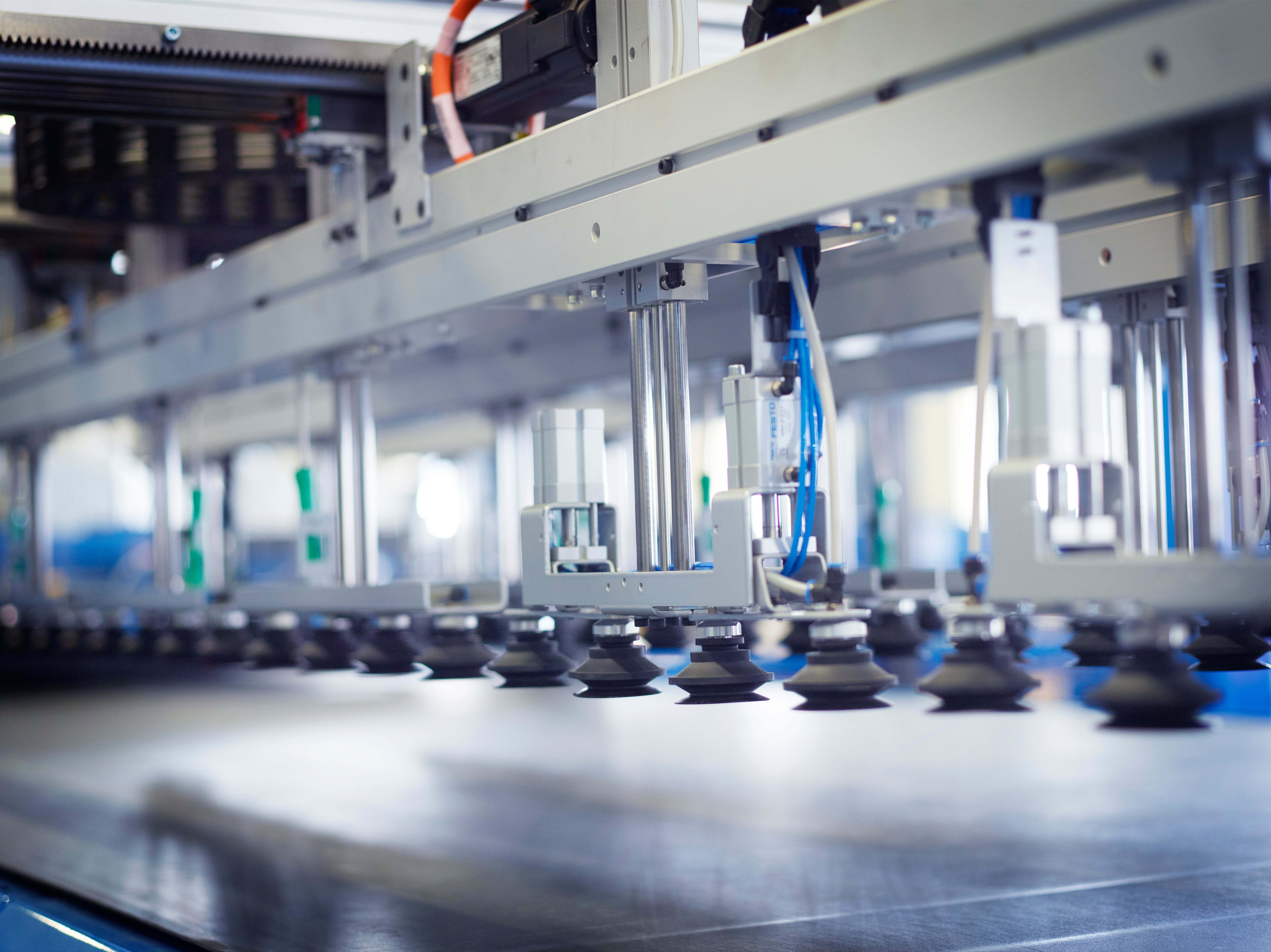 Industriell ventilationsutrustning med metallkomponenter och blå detaljer i fabriksmiljö