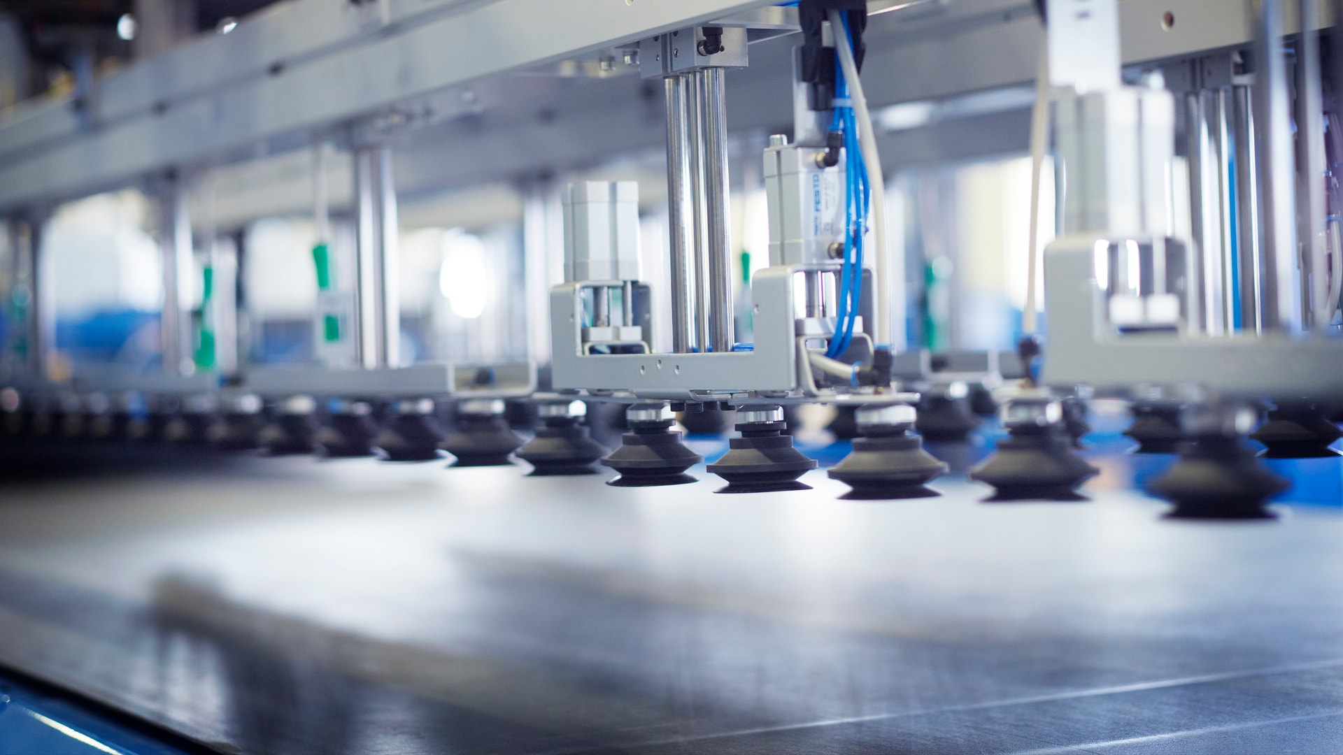 Industriell ventilationsutrustning med metallkomponenter och blå detaljer i fabriksmiljö