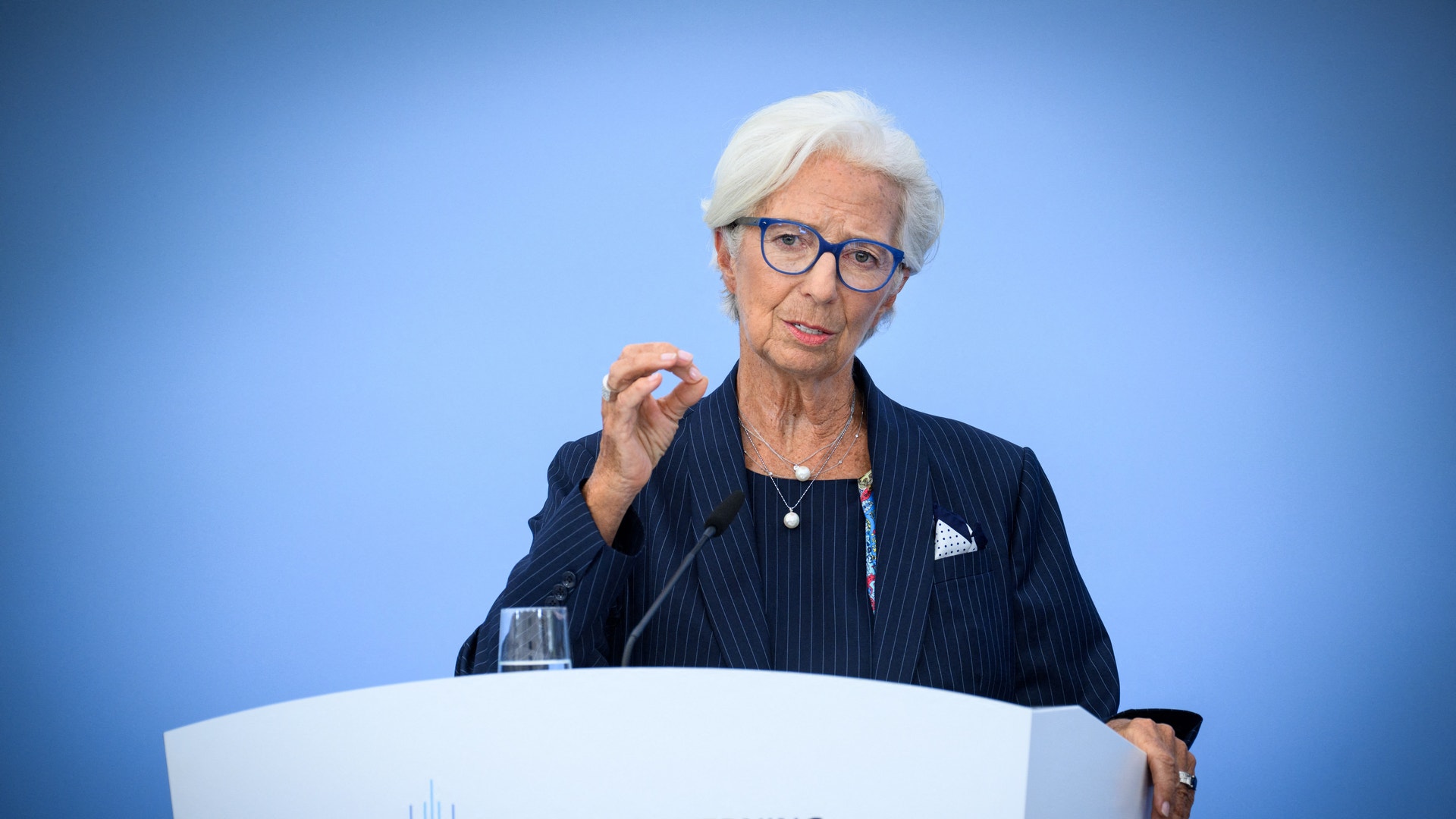 En kvinna talar och gestikulerar vid ett podium under ett möte med ECB:s råd i Berlin.