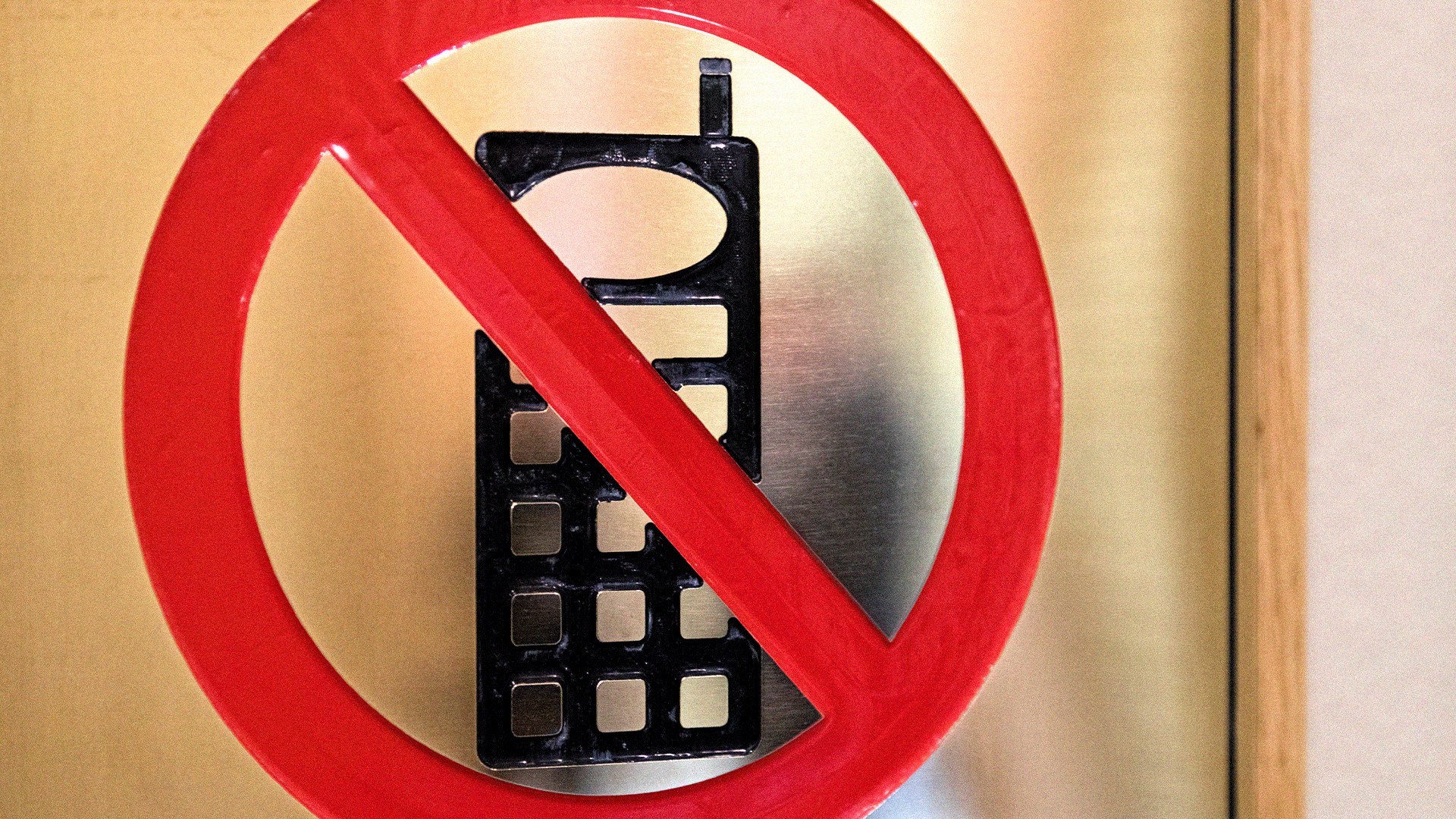 Förbudssymbol som visar en mobiltelefon med ett rött snedstreck över. Symbolen anger att mobiltelefoner är förbjudna.