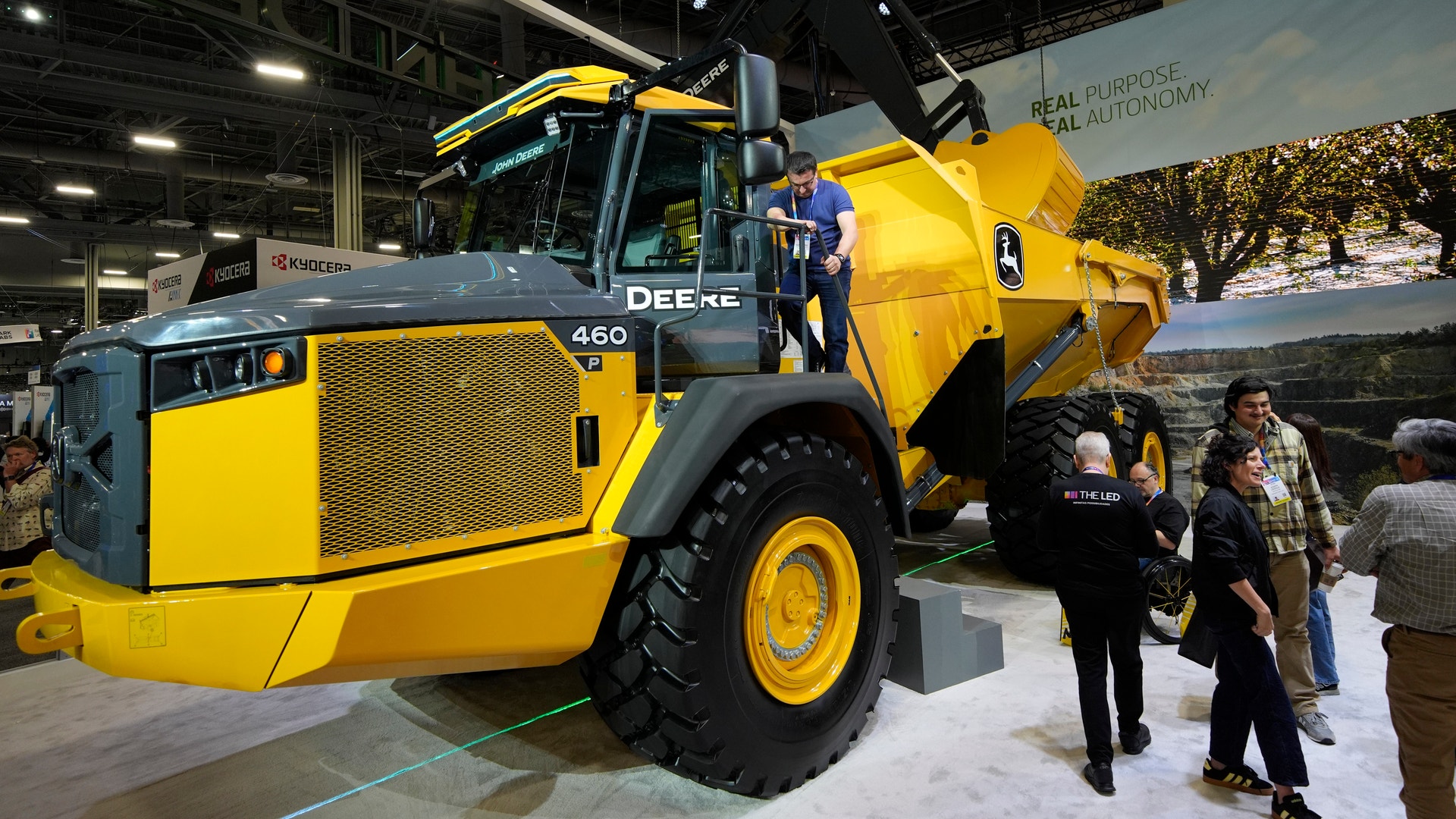 Gul och svart John Deere-lastbil på utställning med besökare