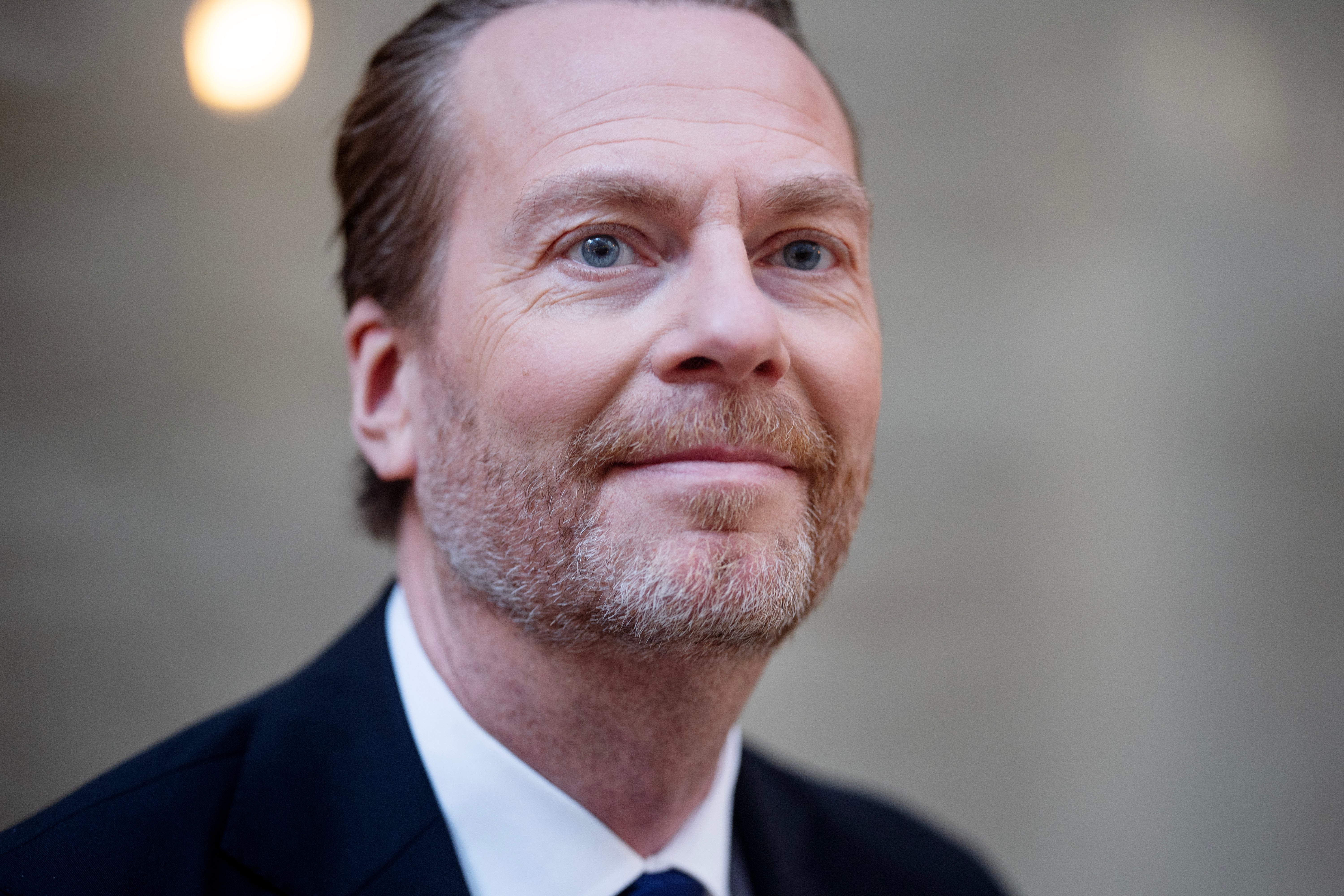 Porträttfoto av en man i mörk kostym och slips.