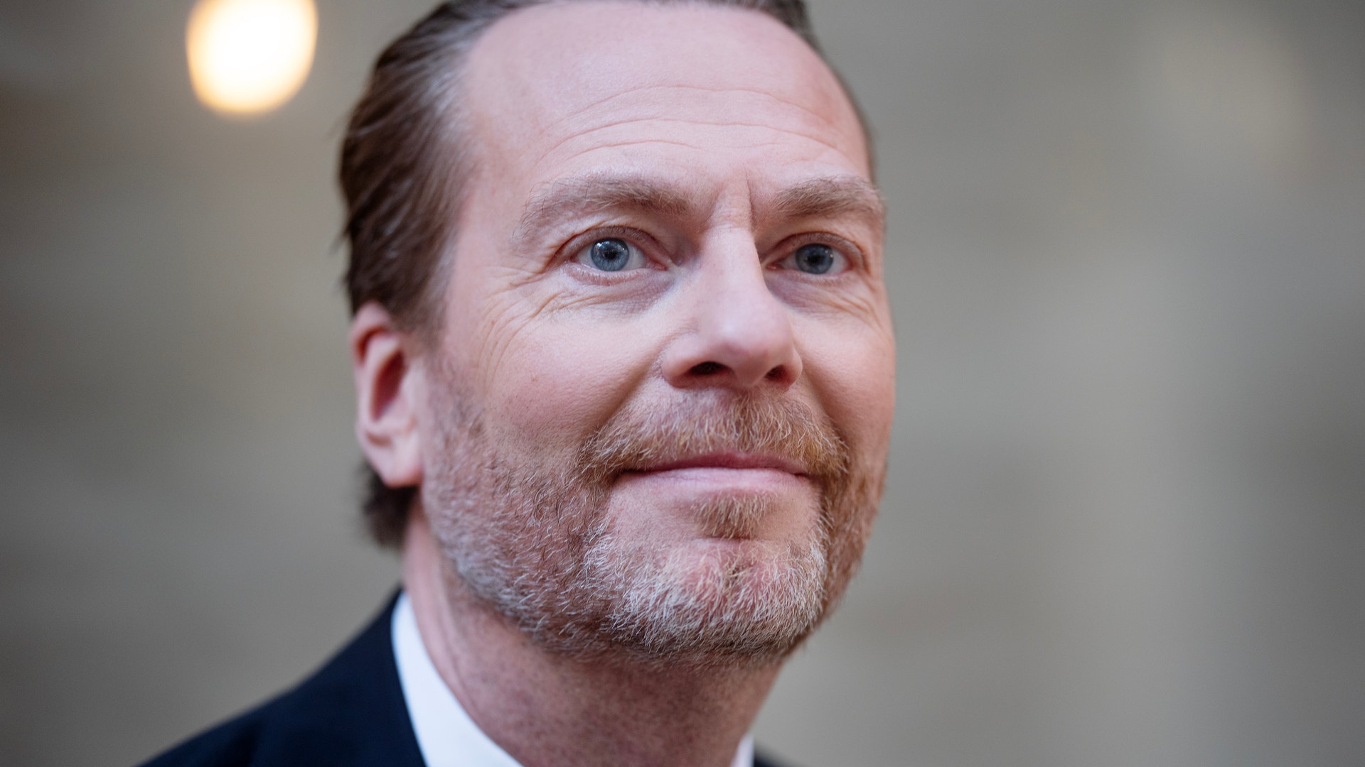 Porträttfoto av en man i mörk kostym och slips.