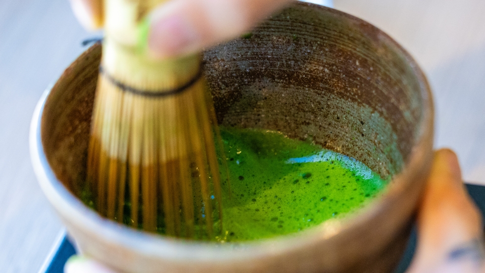 Bild på matcha som tillreds i skål med visp.
