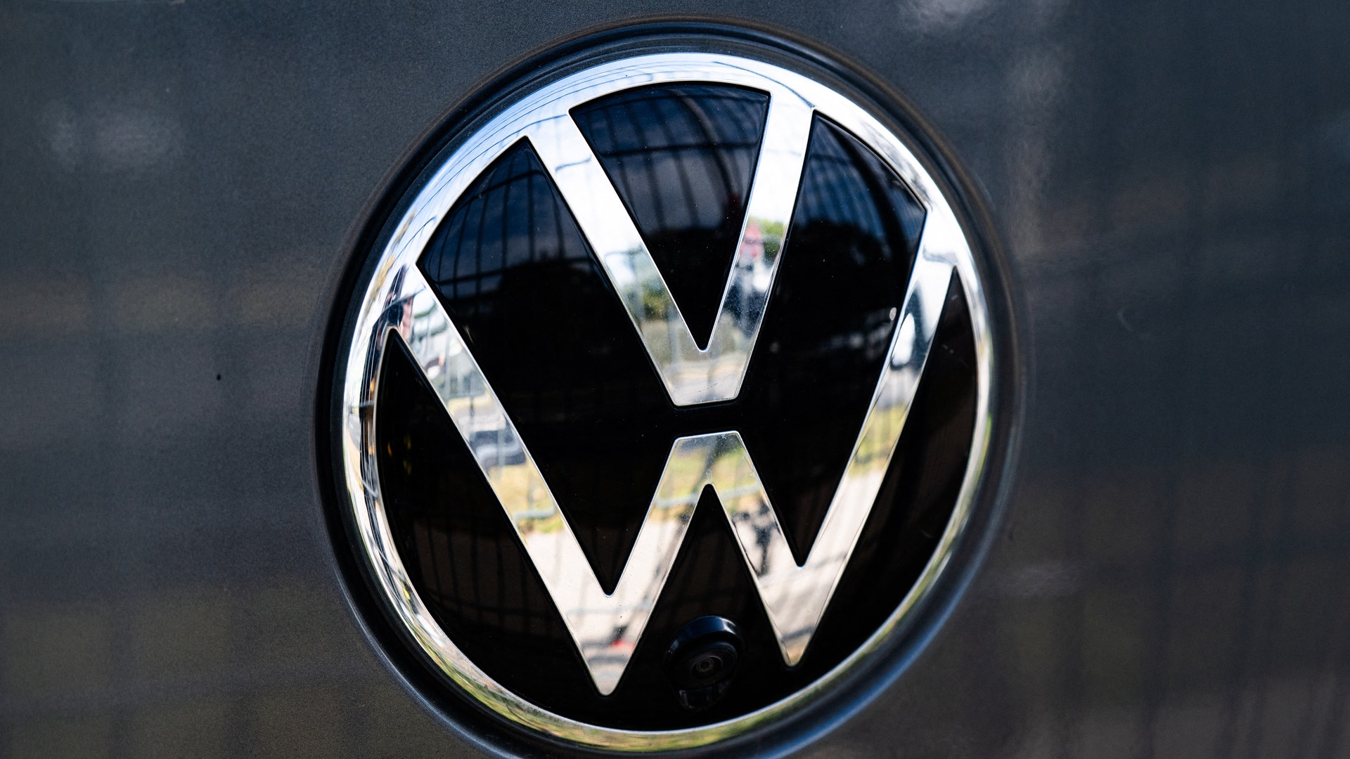 Volkswagens logotyp på baksidan av en grå bil.
