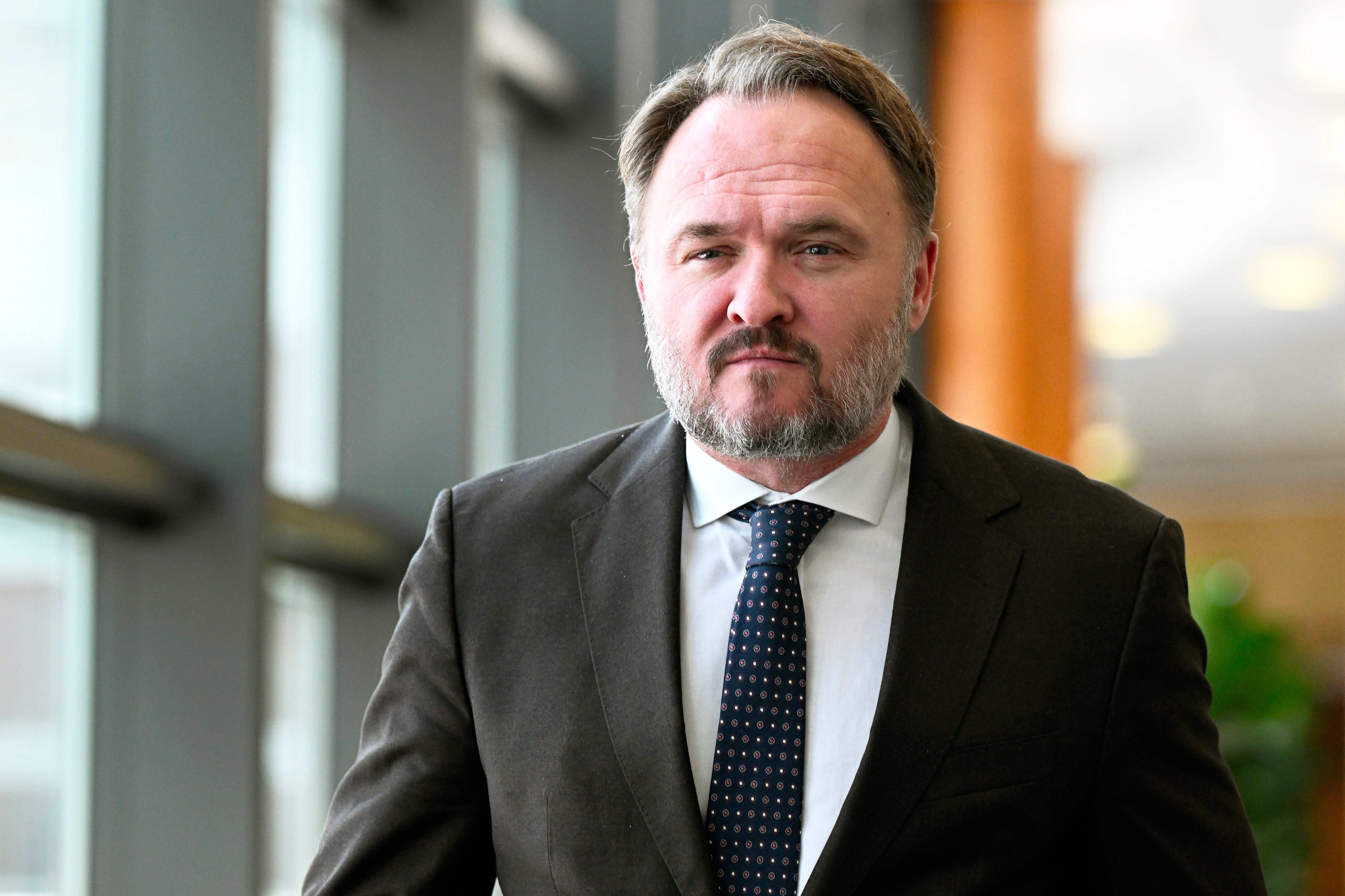 Porträtt av en man i kostym och slips i en modern kontorsmiljö