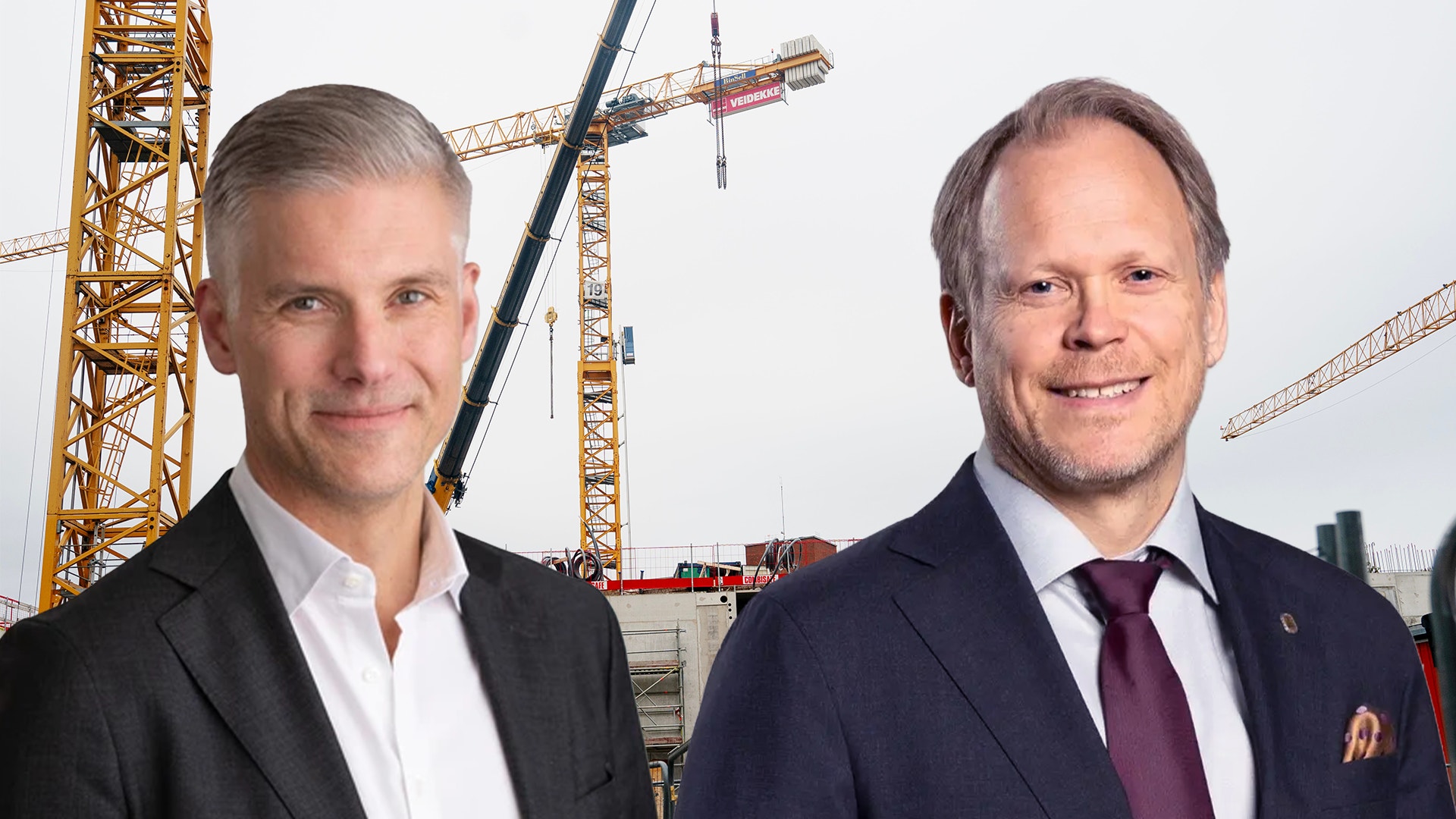 Två män i kostym ler mot kameran, med byggkranar på en byggarbetsplats i bakgrunden.