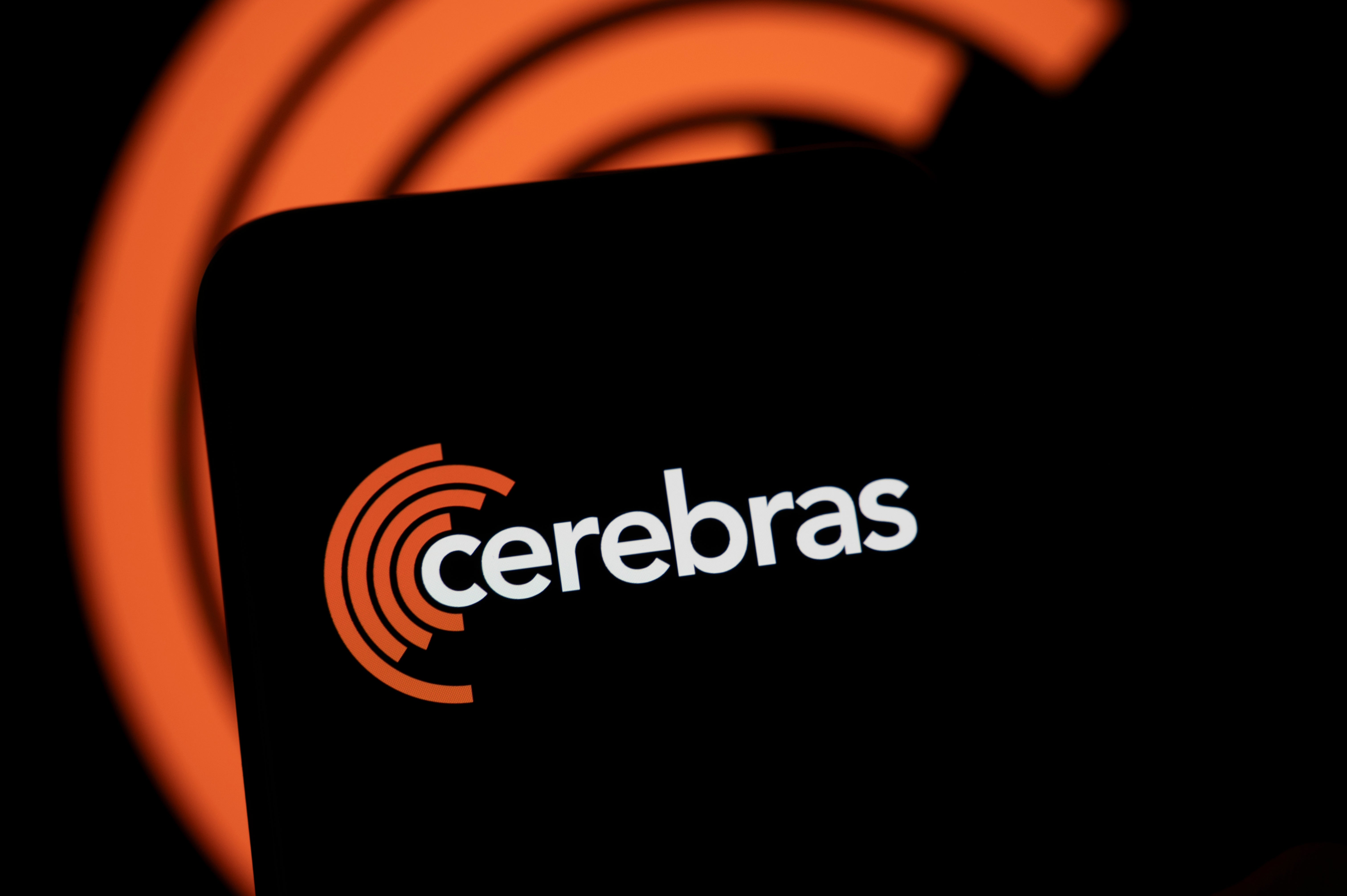 Cerebras logotyp med orange vågformad symbol och företagsnamn på svart bakgrund