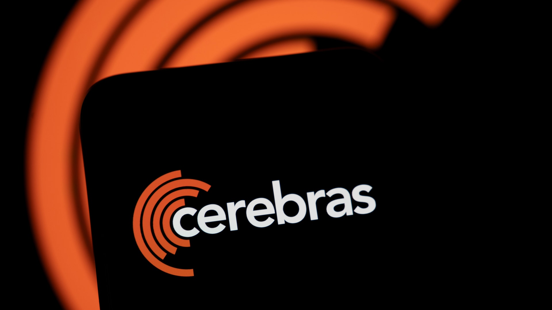 Cerebras logotyp med orange vågformad symbol och företagsnamn på svart bakgrund