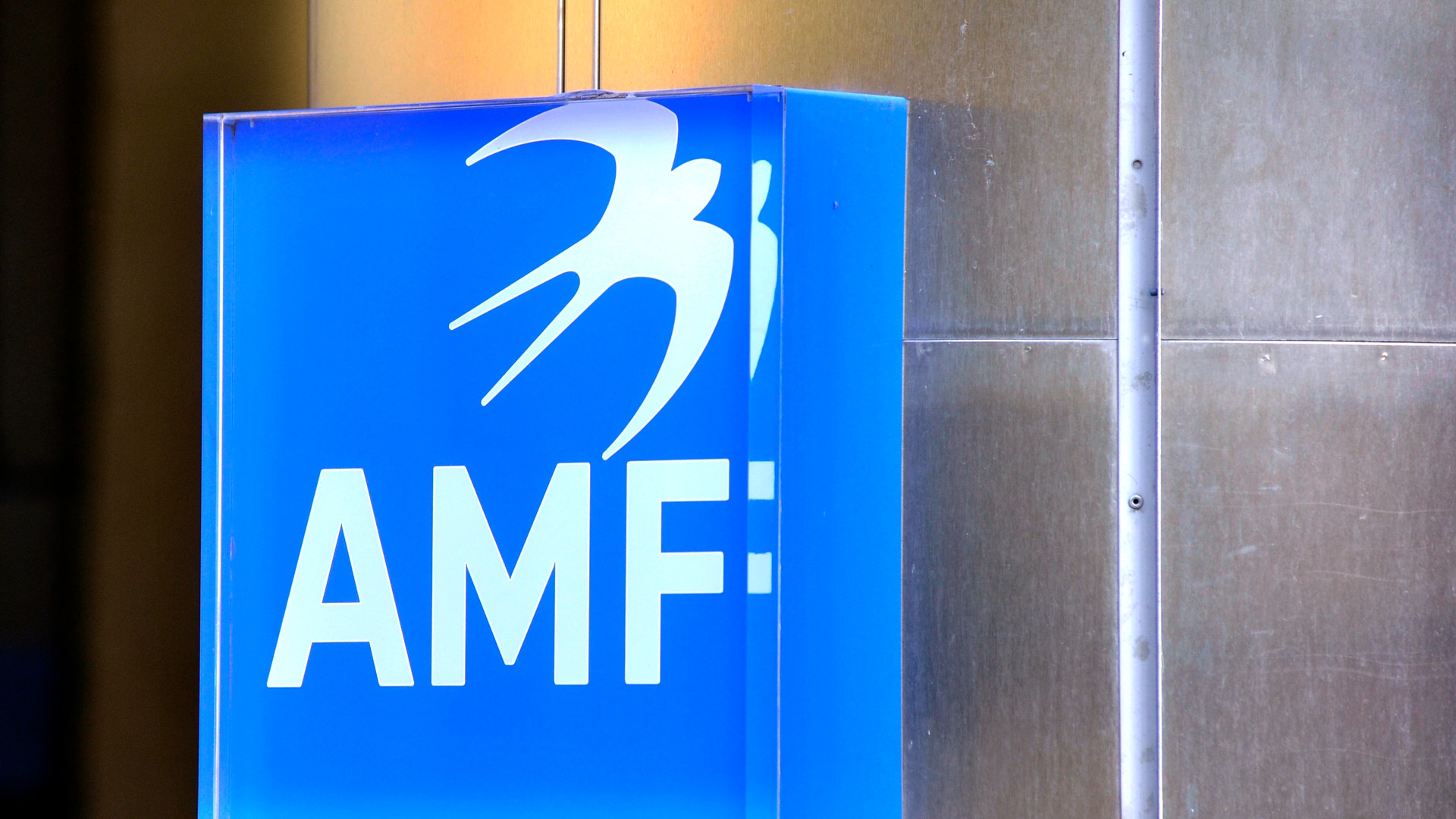 Blå väggmonterad skylt med AMF-logotypen och texten AMF i vitt