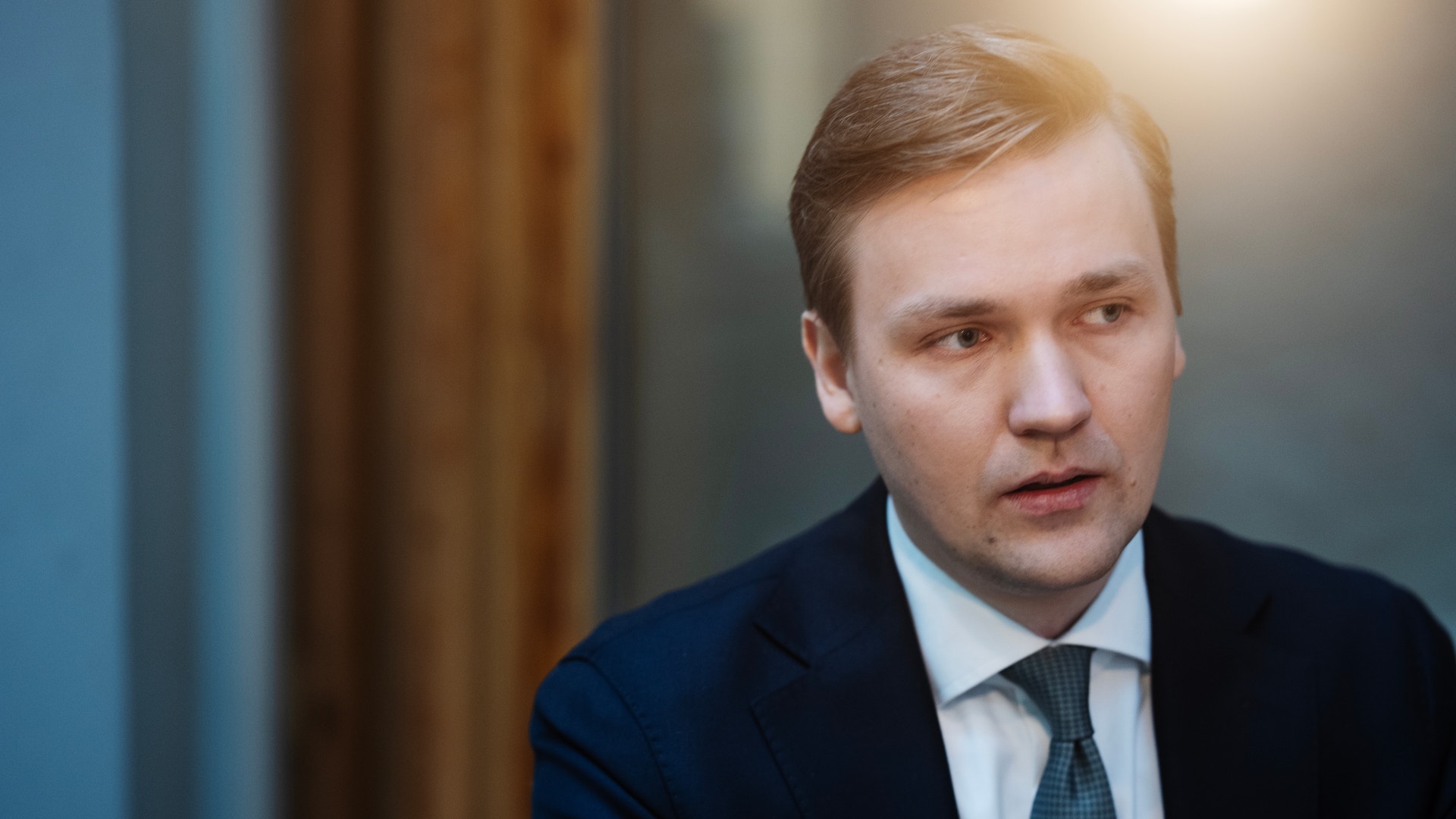 Porträtt av en man i mörkblå kostym och slips