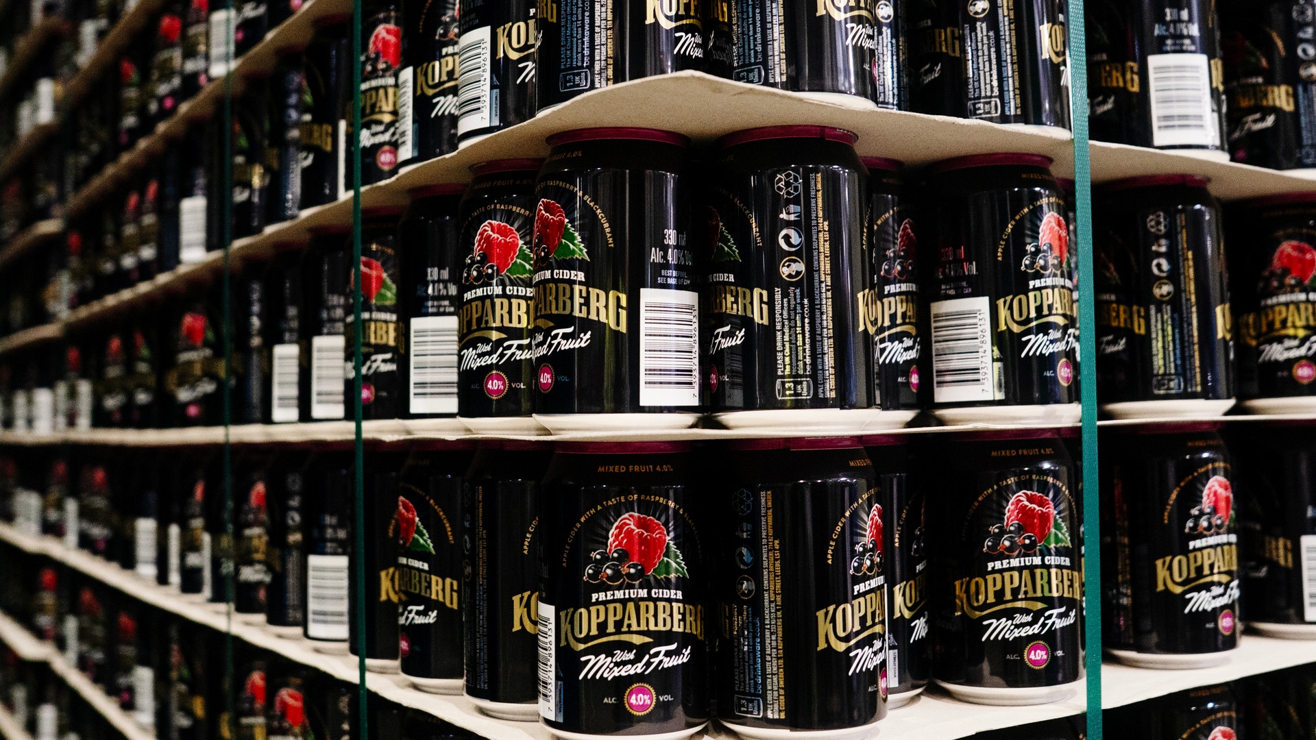 Hylla med svarta ölburkar från Kopparberg med röda och gula etiketter.