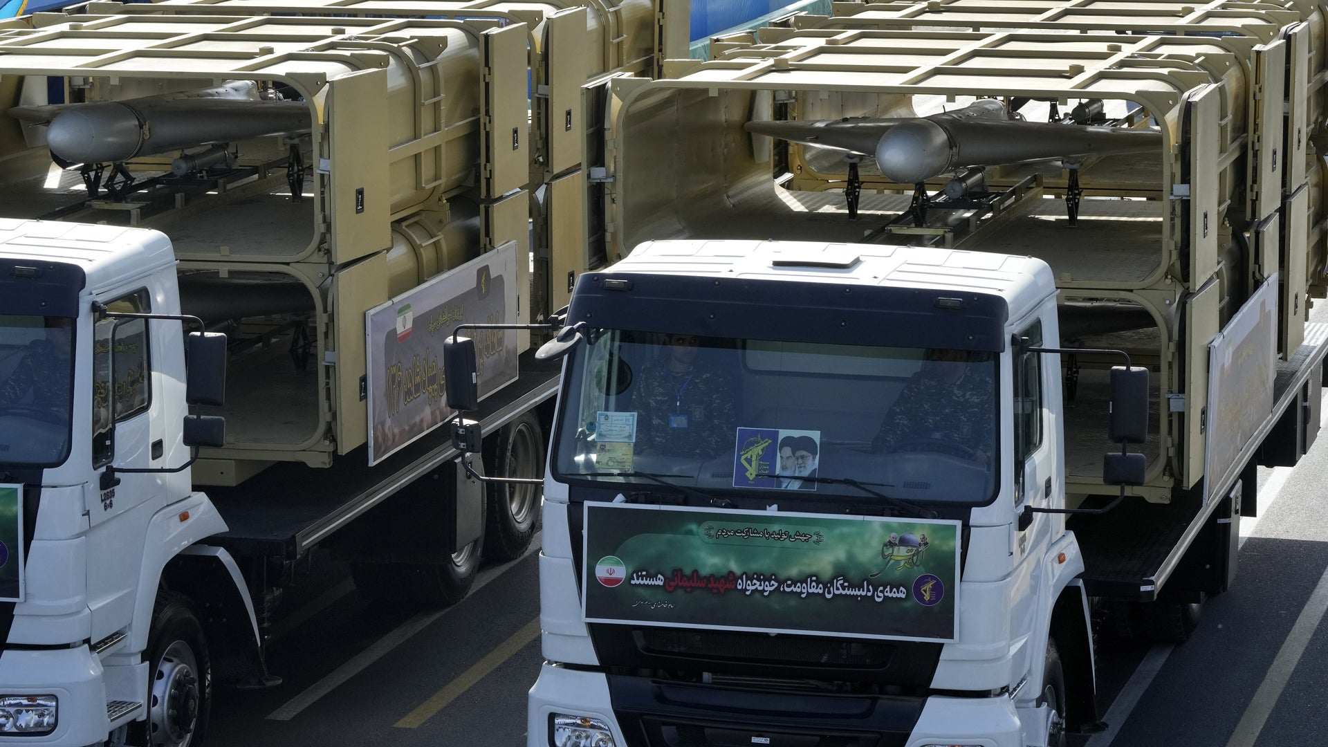 En rad med lastbilar parkerade sida vid sida på en solig dag.