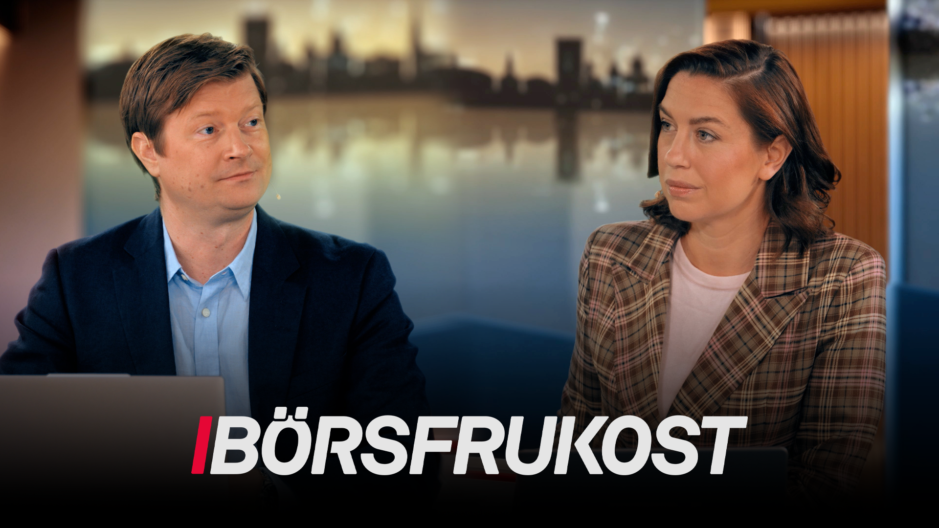 Två personer sitter och samtalar framför ett fönster med stadshorisont i bakgrunden. Texten Börsfrukost visas längst ned på bilden.