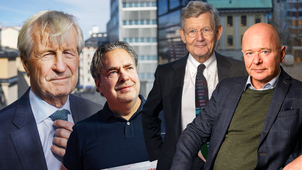 Fyra män står tillsammans och poserar för en gruppfoto med stadssilhuett i bakgrunden.