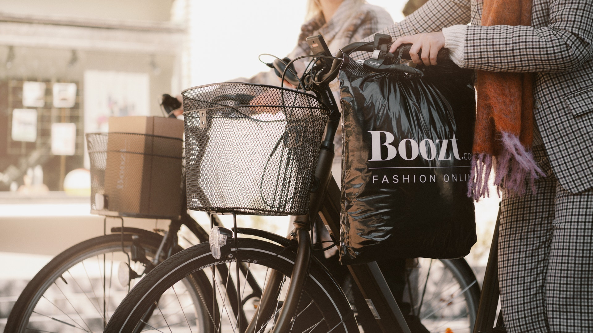 Boozt-kasse och kvinnor som drar en cykel.