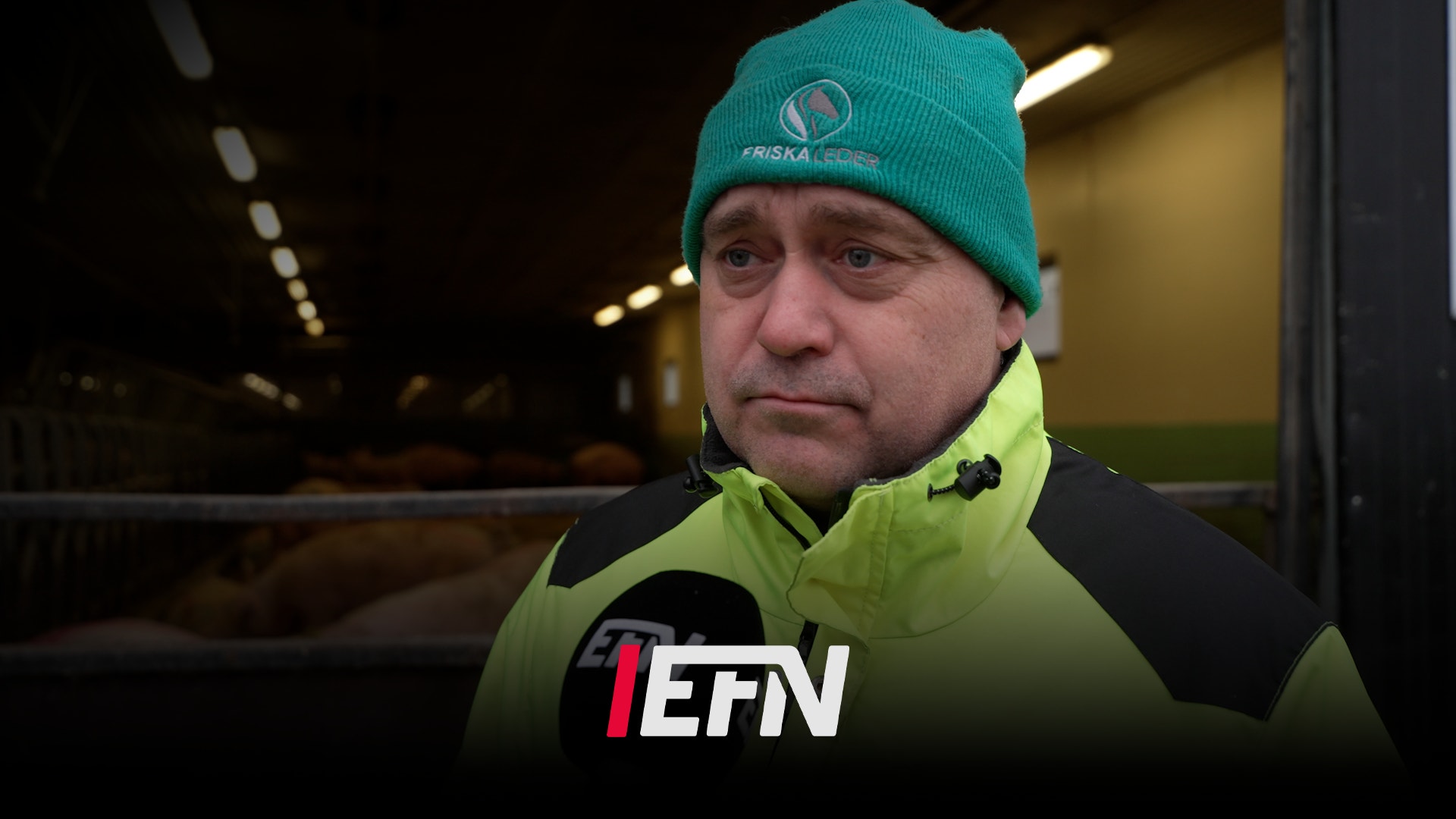 En man med glasögon och keps framför jordbruksmaskiner